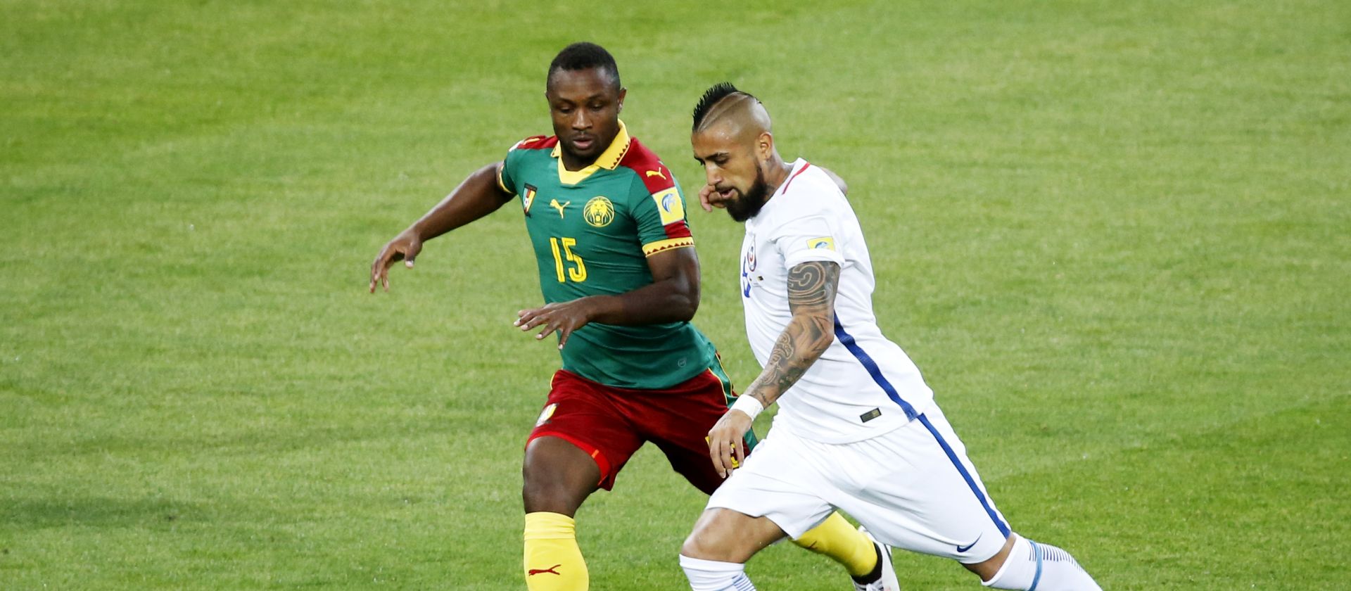 epa06035837 Sebastien Siani (L) of Cameroon in action against Arturo Vidal of Chile during the FIFA Confederations Cup 2017 group B soccer match between Cameroon and Chile at the Spartak Stadium in Moscow, Russia, 18 June 2017.  EPA/SERGEI CHIRIKOV