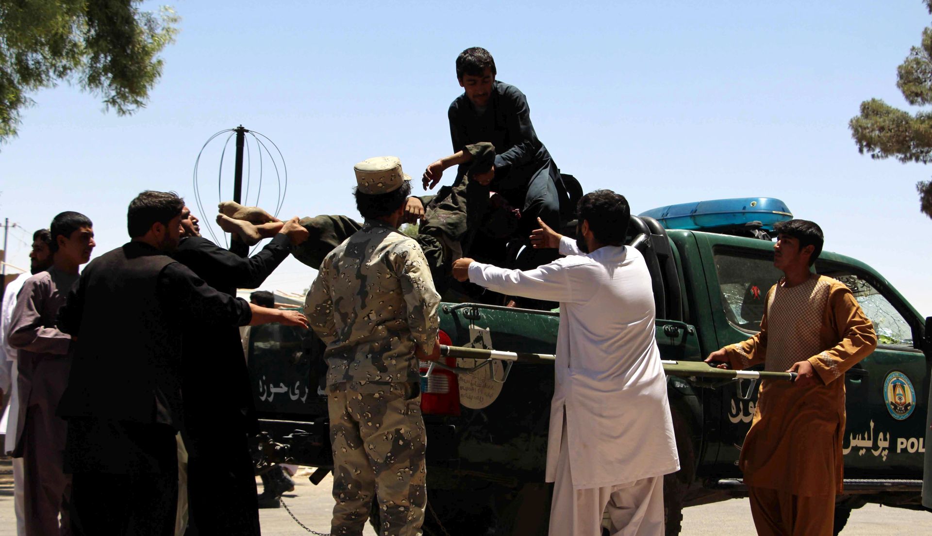 epa06042875 People carry an Afghan man who was injured in a suicide bomb blast, to a local hospital, in Lashkargh, capital of Helmand province, Afghanistan, 22 June 2017. According to media reports 29 people were killed in a suicide bomb blast near Kabul bank in Lashkargh on 22 June.  EPA/WATAN YAR
