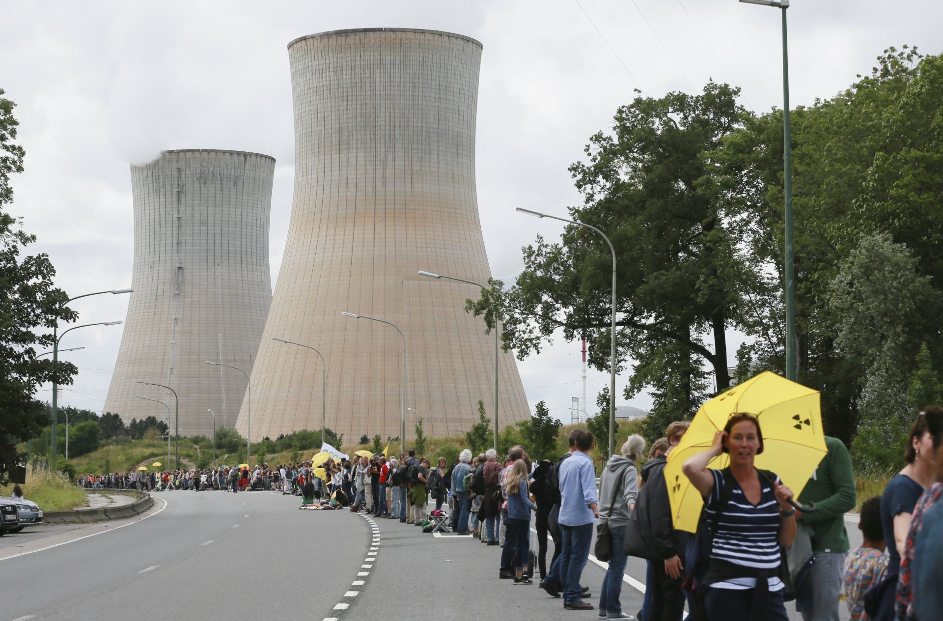 epa06049581 People take part in a tri-national human chain action, near the nuclear power plant of Tihange, Belgium, 25 June 2017. Thousands of people were expected to take part in the event trying to form a 90 km human-chain starting in Tihange, passing by Maastricht in the Netherlands and ending in Aachen, Germany. The organizers of the action demand the immediate shutdown of the nuclear power plants Tihange 2 and Doel 3.  EPA/OLIVIER HOSLET
