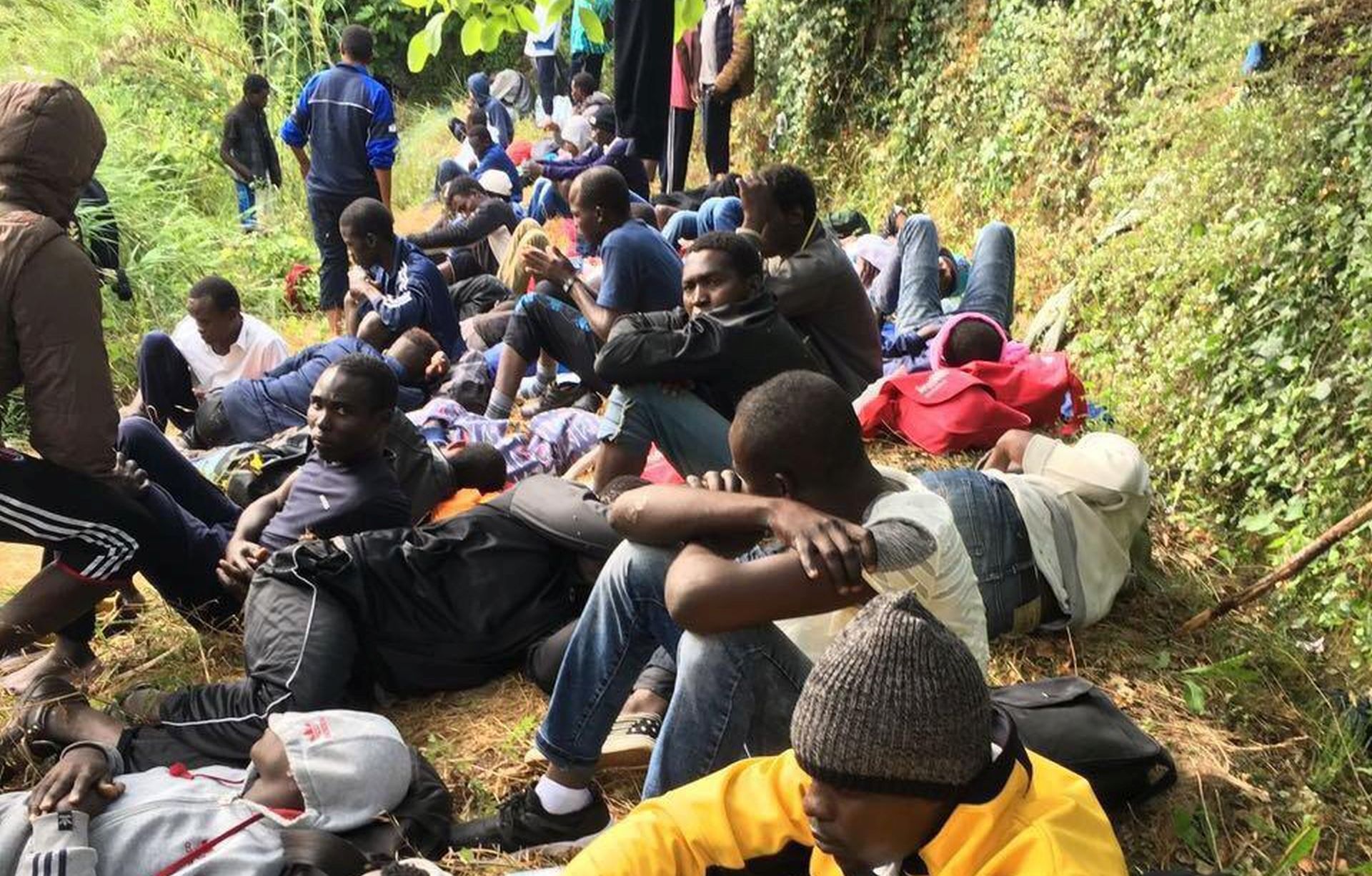 epa06051359 Migrants rest while hiding in the woods between the Italian municipalities of Ventimiglia and Olivetta San Michele near the French-Italian border southwest of Genoa, Italy, 26 June 2017. Around 400 refugees left their camp on the banks of the Roja River in Ventimiglia shortly after midnight in an attempt to cross the French border. The group were allegedly led by German activists.  EPA/CHIARA CARENINI