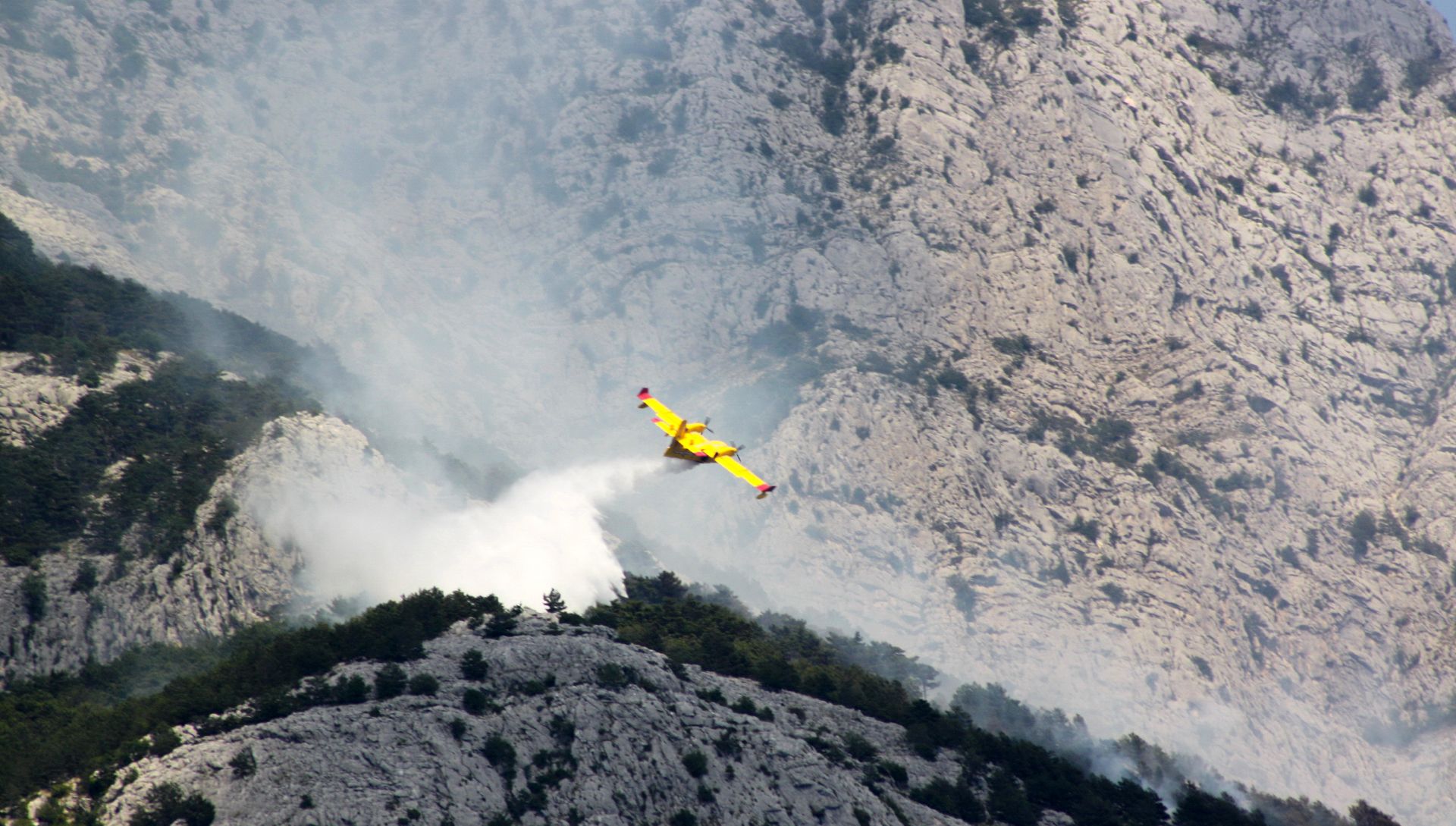 Makarska, 19.6.2017 - Poarite na Makrskom primorju, gdje su se vatrogascima u gaenju pridruili i pripadnici Oruanih snaga, u ponedjeljak je obiao potpredsjednik Vlade i ministar obrane Damir Krstièeviæ, zahvalivi gasiteljima na iznimnom angamanu kako bi se poarite èim prije saniralo. Na slici kanader gasi poar iznad Makarske.
foto HINA/ Jure DIVIÆ/ ua