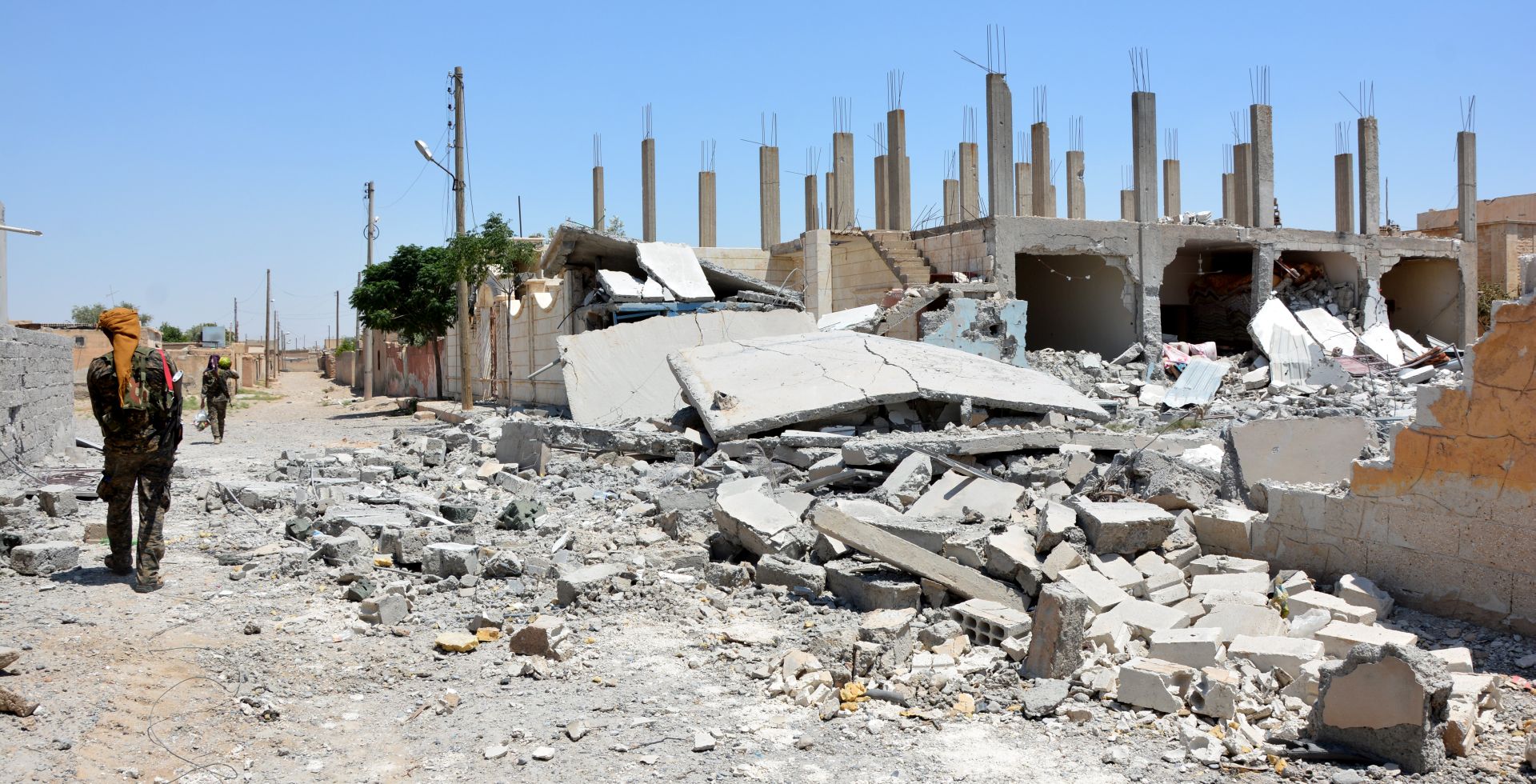 epa06023965 Soldiers patrol next to destroyed buildings at Raqqa city, Syria, 11 June 2017 (Issued 12 June 2017). The People's Protection Unit (YPG, part of the Syrian Democratic Forces, SDF) advanced on the neighbourhoods of al-Sabahyah and al-Jazrah in Raqqa city with the support of the US-led international coalition to fight IS in Syria. Raqqa city is the main stronghold and the capital of IS in Syria and has been under their control since 2014. The operation to recapture it started on 06 June 2017 under the name 'The Grand Battle' by the Syrian Democratic Forces (QSD or SDF) and supported by a US-led coalition.  EPA/YOUSSEF RABIE YOUSSEF
