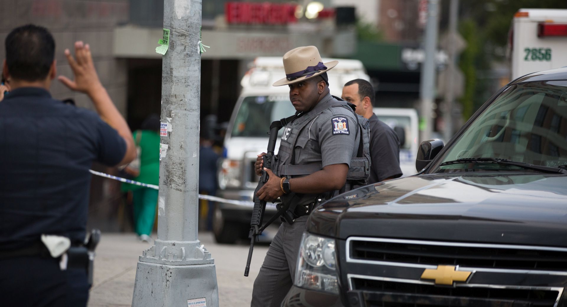 epa06058787 An officer keeps watch in front of the building after a shooter opened fire, killing at least one doctor and shooting six others before committing suicide at the Bronx-Lebanon Hospital Center in the Bronx, New York, USA, 30 June 2017.  EPA/Kevin Hagen