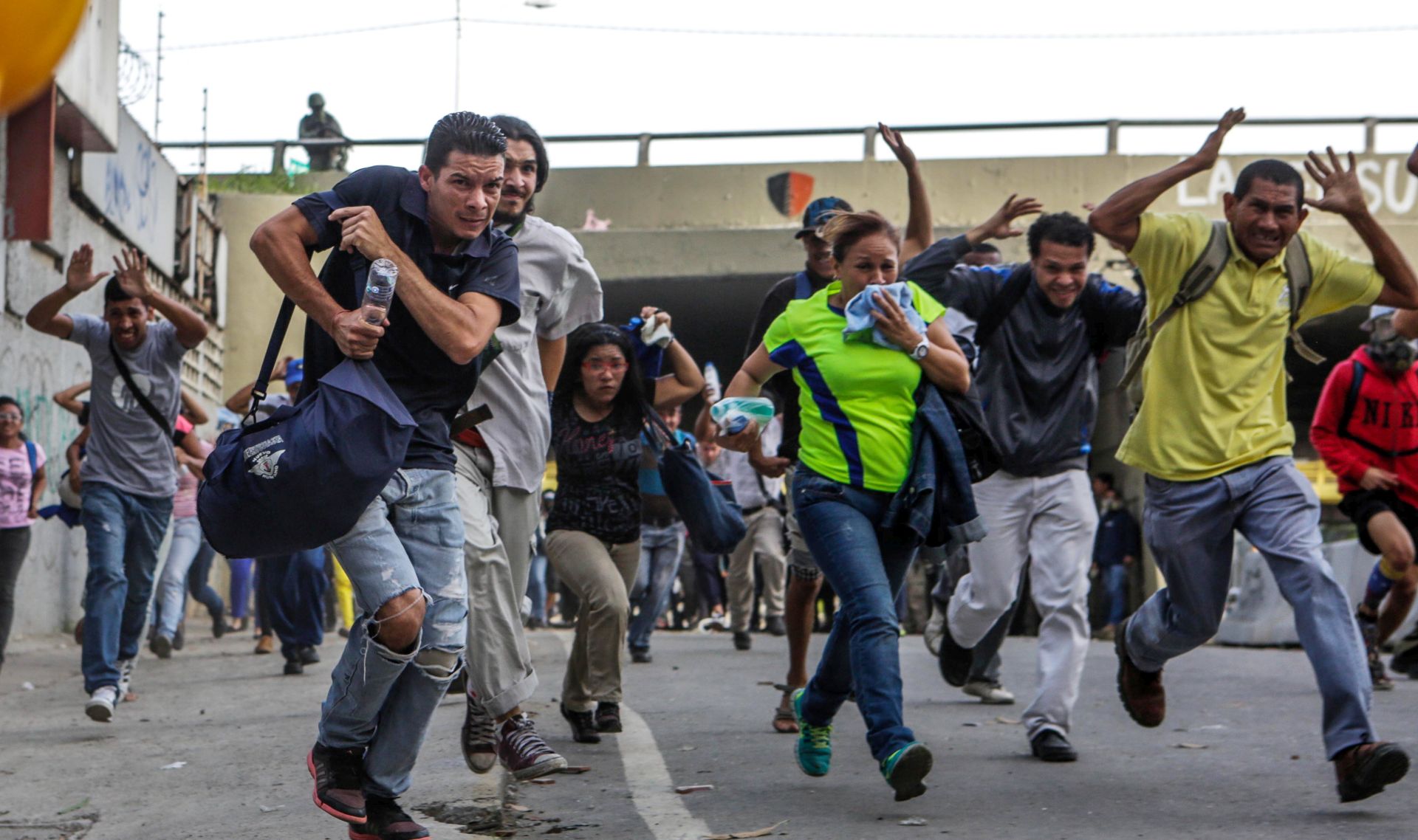 epa06080198 People run during clashes between opposition protesters and the Bolivarian National Guard (GNB) during a demonstration in Caracas, Venezuela, 10 July 2017. Opposition protesters and members of the Bolivarian National Guard (GNB) clashed in various parts of Caracas during a massive new street demonstration called by the opposition throughout the country to protest against the constitutional process promoted by the government of President Nicolas Maduro.  EPA/CRISTIAN HERNANDEZ