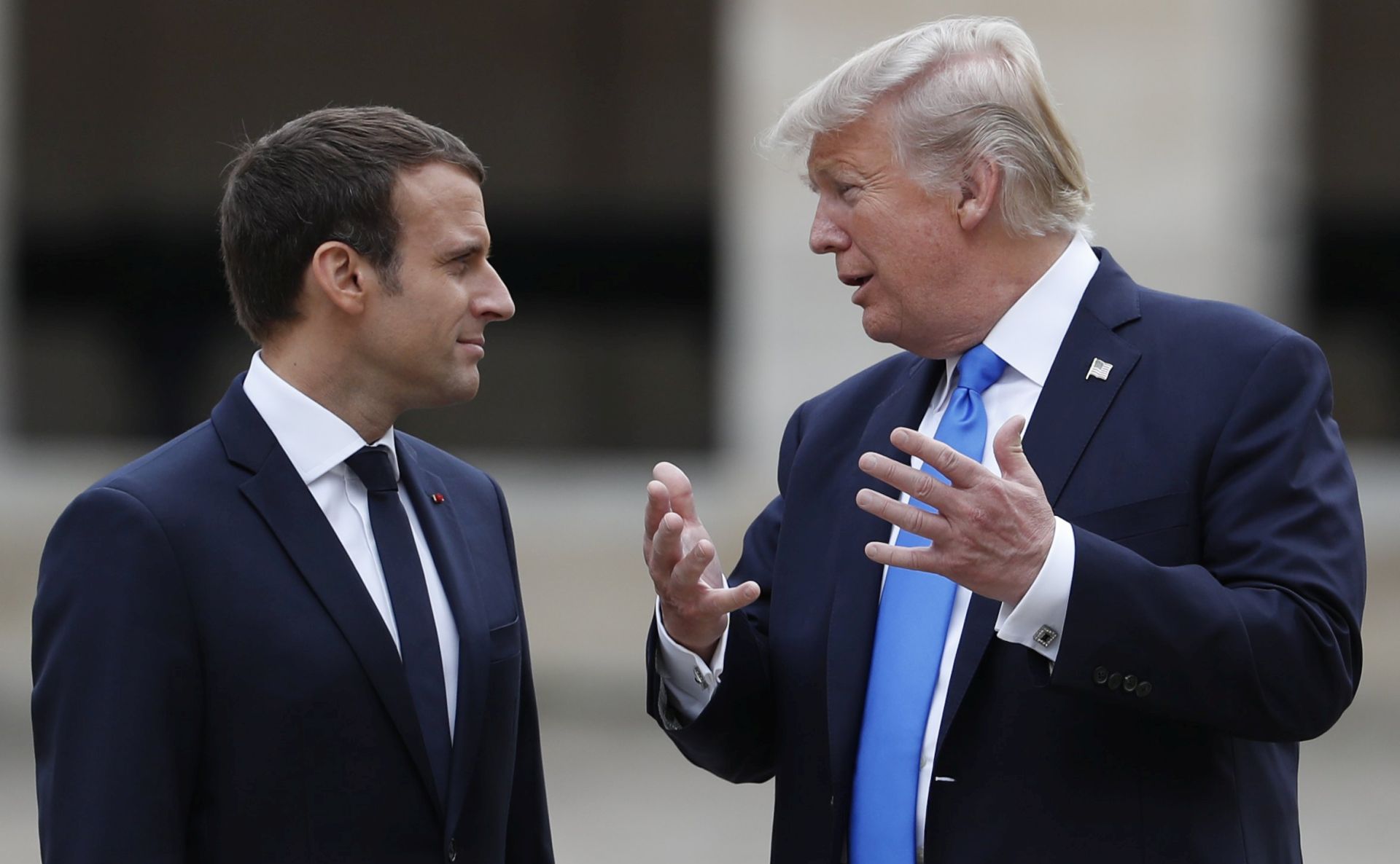 epa06085202 French President Emmanuel Macron (L) and US President Donald J. Trump (R) talk while walking in the courtyard as they leave after a welcoming ceremony at the Les Invalides in Paris,France, 13 July 2017.  EPA/YVES HERMAN / POOL MAXPPP OUT
