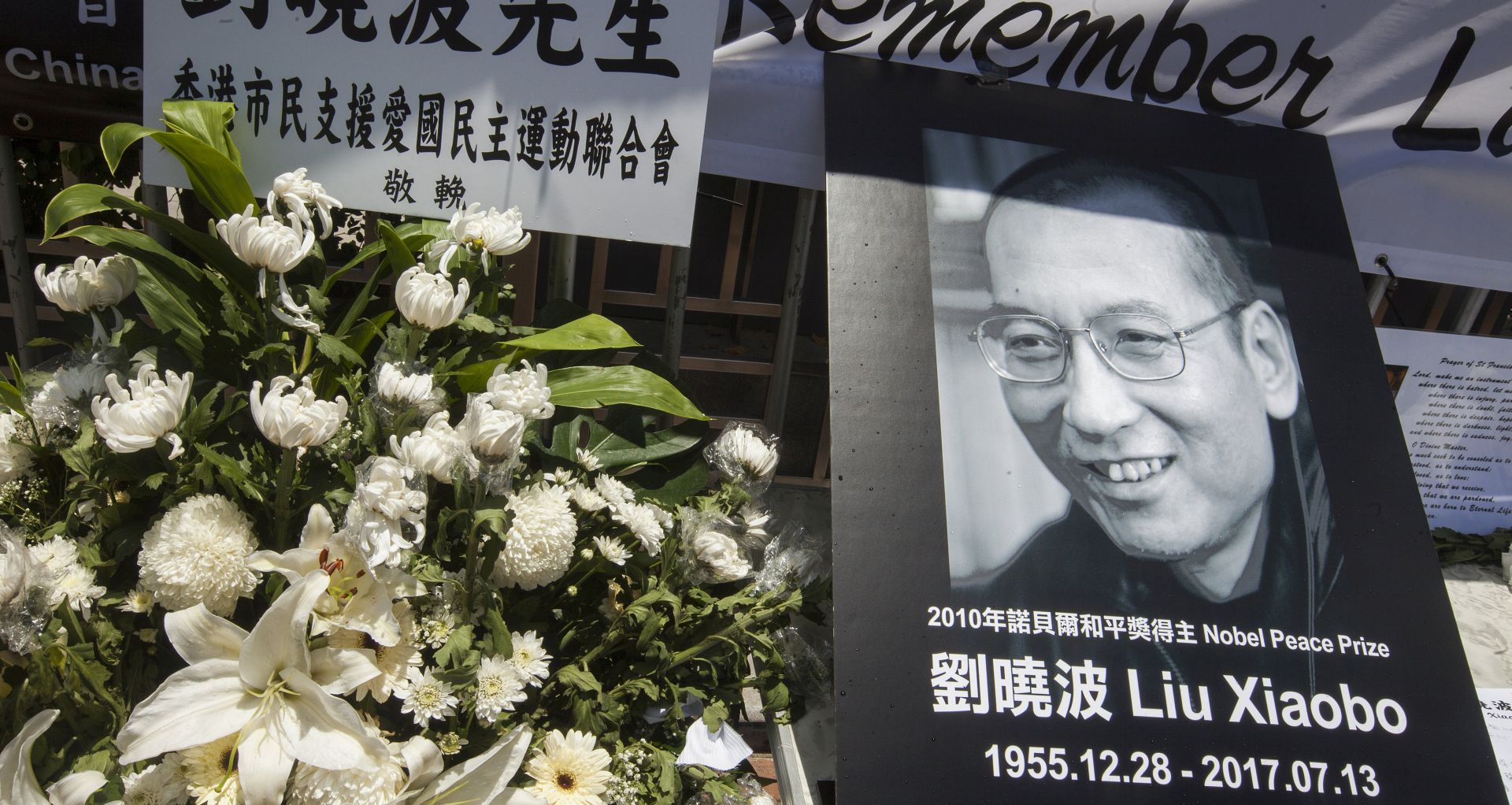 epa06086235 A makeshift shrine stands outside the China Liaison Office in Western District, Hong Kong, China, 14 July 2017. Human rights and pro-democracy activists in Hong Kong are calling on the Chinese government to release Liu Xia, the widow of Liu Xiaobo. According to media reports on 13 July citing official sources, Liu Xiaobo has died aged 61.  EPA/ALEX HOFFORD