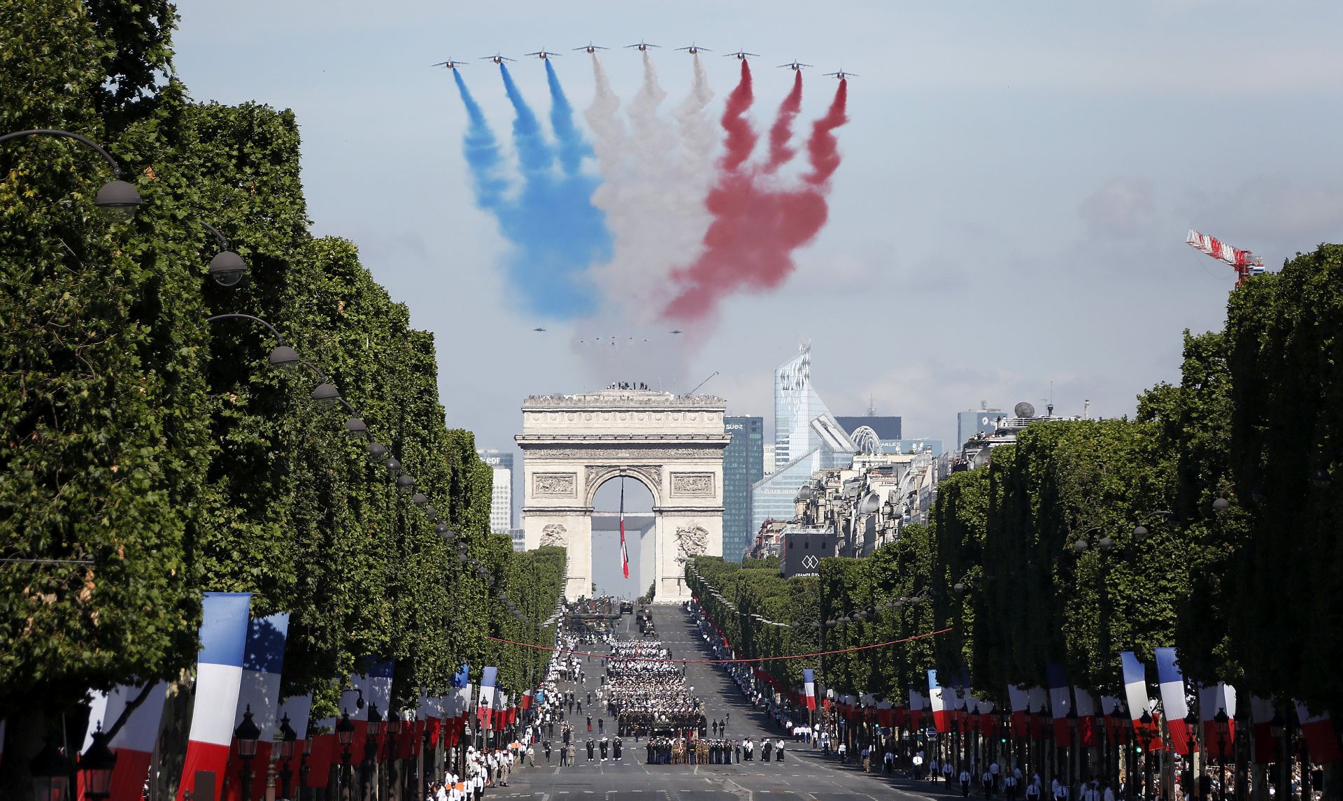 epa06086380 Alpha jets fly over the Arc de Triomphe leaving a red, white and blue trail during the annual Bastille Day celebrations in Paris, France, 14 July 2017. Bastille Day, the French National Day, is held annually on 14 July to commemorate the storming of the Bastille fortress in 1789.  EPA/IAN LANGSDON