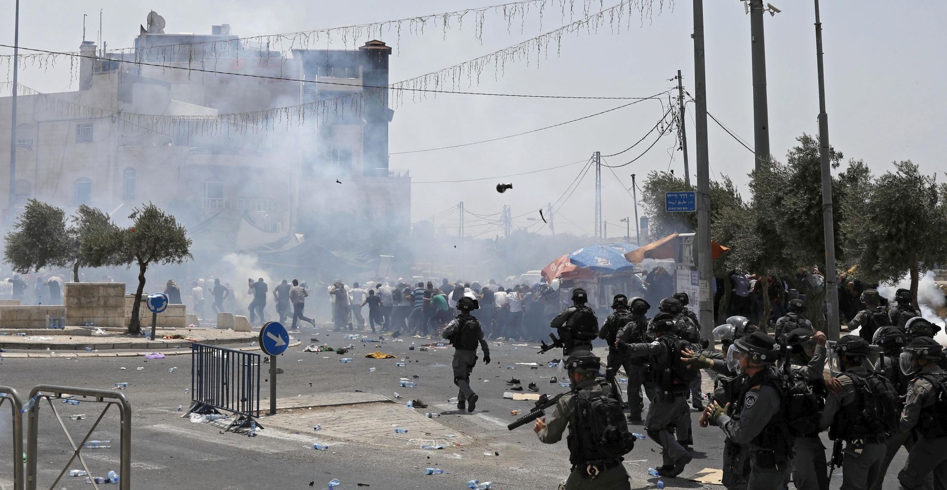 epa06101064 Palestinians hide as Israeli Border Police threw stun grenades at a mass Friday prayer in the East Jerusalem neighborhood of Ras al-Amud overlooking the Old City of Jerusalem, 21 July 2017. Israel's security cabinet decided not to dismantle the new security measures at the Al-Aqsa Mosque. Islamic authorities of the al-Aqsa Mosque compound, including the mufti of Jerusalem, called on Palestinian Muslims not to go through the electronic gates installed by the Israeli police and rejected all procedures that change the historic situation of the mosque. Israel authorities installed metal detectors at the entrance to the al-Aqsa compound after a shooting attack carried by Israeli Arab on 14 July against Israeli police at the al-Aqsa compound, killing two Israeli policemen and the three attackers.  EPA/ABIR SULTAN
