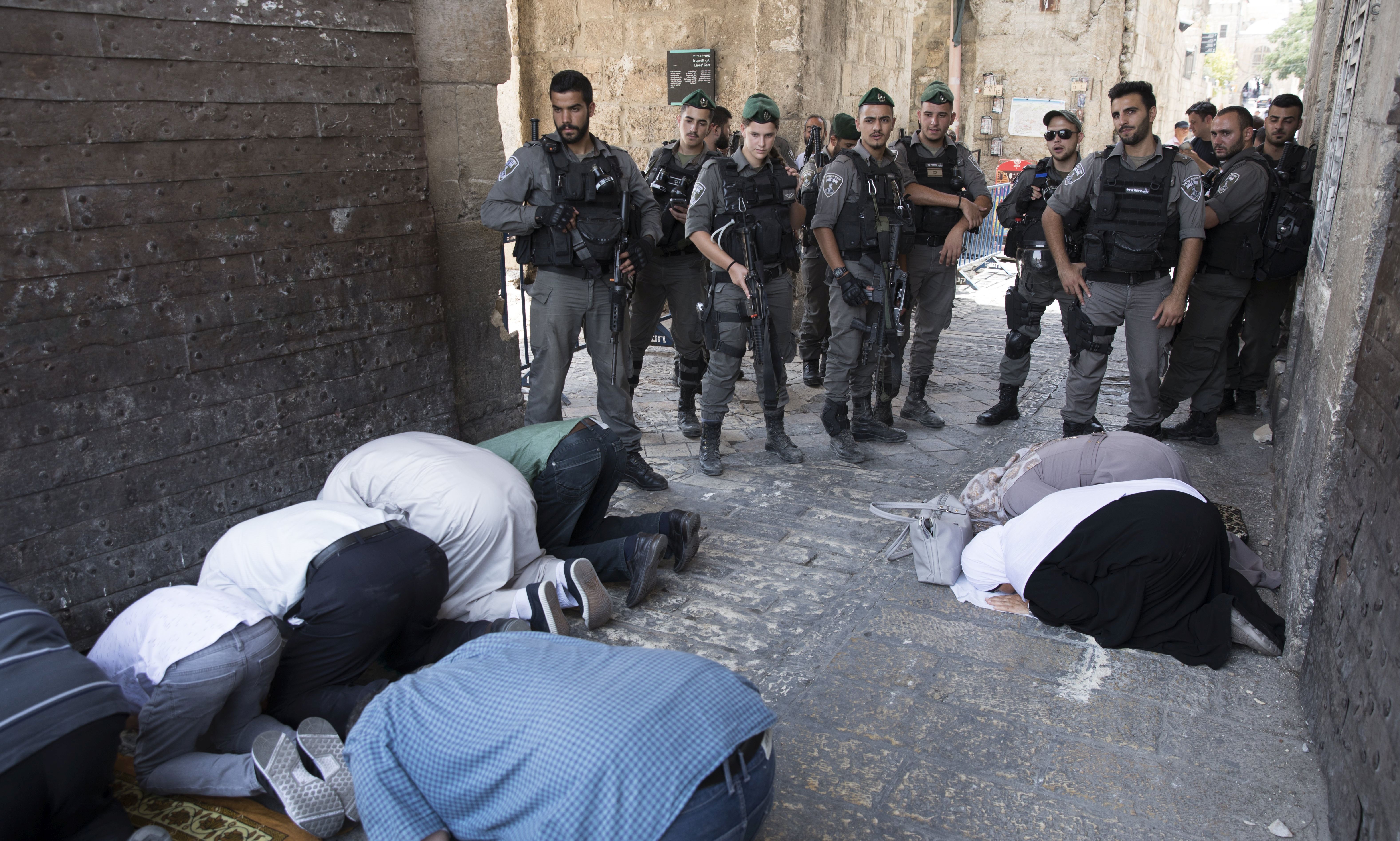 epa06108355 Israeli border police on duty as Palestinians pray at the Lion's Gate in the Old City of Jerusalem near the entrance to the Haram el-Sherif (Noble Sanctuary), or The Temple Mount to Jews, at the Old City of Jerusalem, 25 July 2017. During the night police removed the controversial metal detectors that were placed in the wake of a shooting of two Israeli police officers at this popular entrance to the Al-Aqsa Mosque, amid a diplomatic easing of recent tensions. The mufti of Jerusalem called on Muslims not to enter and  pray at the  Al-Aqsa Mosque, even though Israel had been dismantled metal detectors  EPA/ABIR SULTAN
