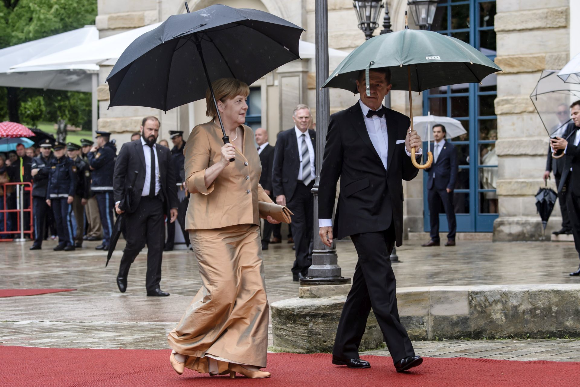 epa06108710 German Chancellor Angela Merkel (L) and her husband Joachim Sauer (R) arrive for the opening of the 106th Bayreuth Festival at the Richard-Wagner-Festspielhaus (Bayreuth Festspielhaus), in Bayreuth, Germany, 25 July 2017. The Richard Wagner festival opens with the opera 'Meistersinger von Nuernberg' and runs until 28 August.  EPA/CLEMENS BILAN