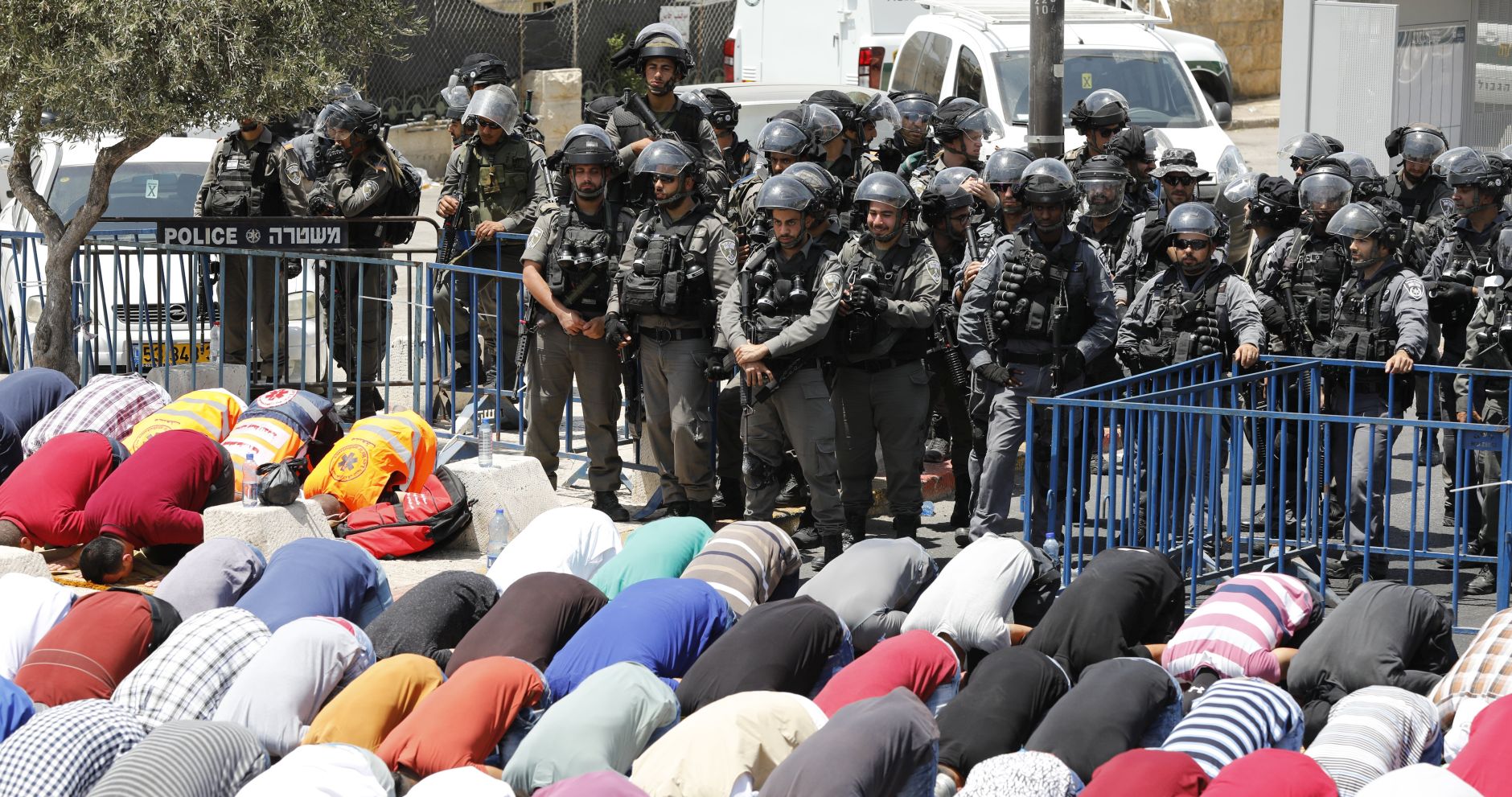 epa06114269 Palestinians pray as Israeli Border Police are on duty during a mass Friday prayer in the East Jerusalem neighborhood of Ras al-Amud overlooking the Old City of Jerusalem, 28 July 2017.  EPA/ABIR SULTAN