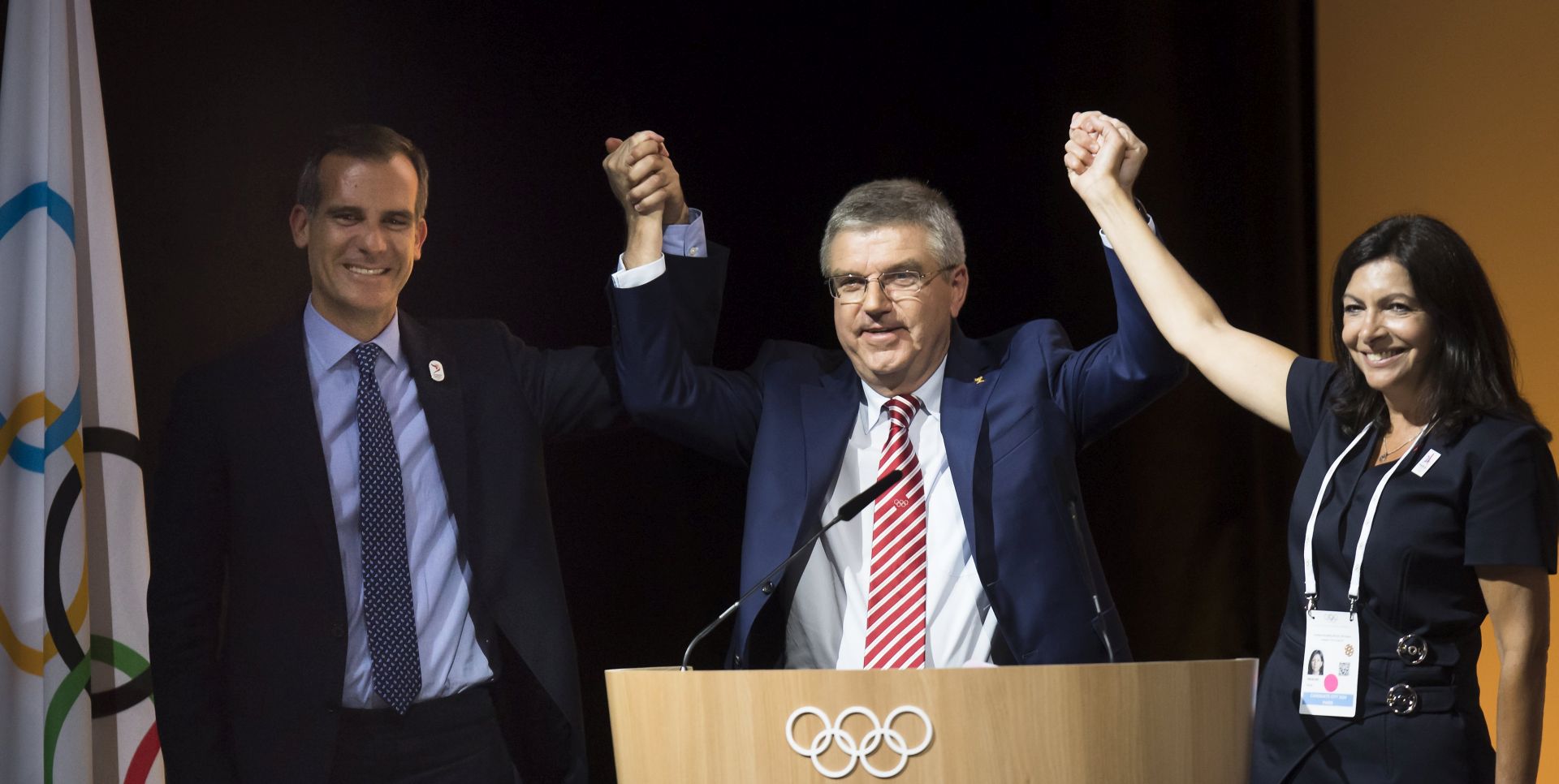 epa06081510 (L-R) Mayor of Los Angeles Eric Garcetti, International Olympic Committee (IOC) President Thomas Bach, and Paris Mayoress Anne Hidalgo pose together during the International Olympic Committee (IOC) Extraordinary Session, at the SwissTech Convention Centre, in Lausanne, Switzerland, 11 July 2017. The session decided to adopt the proposal of the Executive Board to award the Olympic Games 2024 and 2028 at the same time,  EPA/JEAN-CHRISTOPHE BOTT