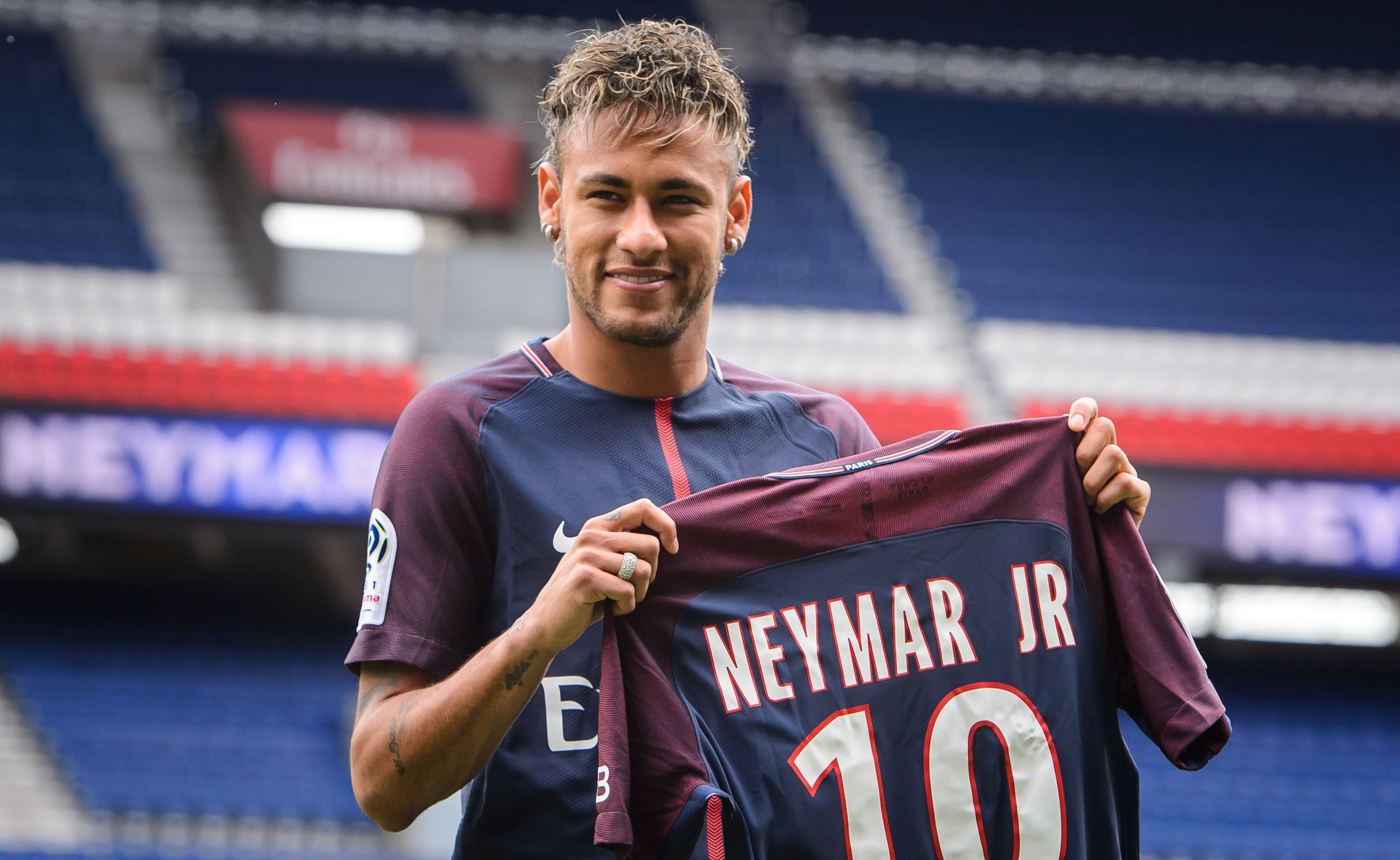 epa06124442 Brazilian striker Neymar Jr. poses for photographs with his new PSG jersey after a press conference at the Parc des Princes stadium in Paris, France, 04 August 2017. Neymar Jr is presented as new player of Paris Saint-Germain (PSG) after completing a record-breaking 222-million-euro move from Spanish side FC Barcelona.  EPA/CHRISTOPHE PETIT TESSON