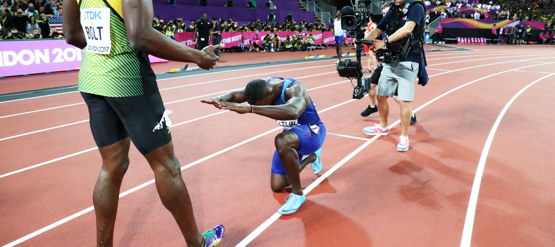 epa06127320 Justin Gatlin kneels in front of Usain Bolt of Jamaica after the men's 100m final at the London 2017 IAAF World Championships in London, Britain, 05 August 2017. Gatlin won gold, Bolt placed third.  EPA/DIEGO AZUBEL