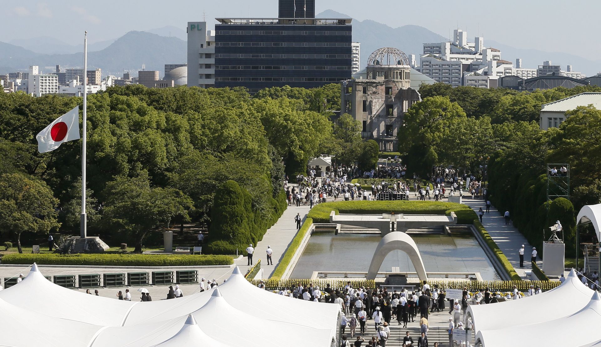 epaselect epa06127591 Citizens walk toward a cenotaph to offer prayers for victims of the 06 August 1945 atomic bombing as the Japanese national flag flies at half mast during a memorial ceremony at the Hiroshima Peace Memorial Park in Hiroshima, western Japan, 06 August 2017. Hiroshima marked the 72nd anniversary of the atomic bombing on 06 August 2017.  EPA/KIMIMASA MAYAMA