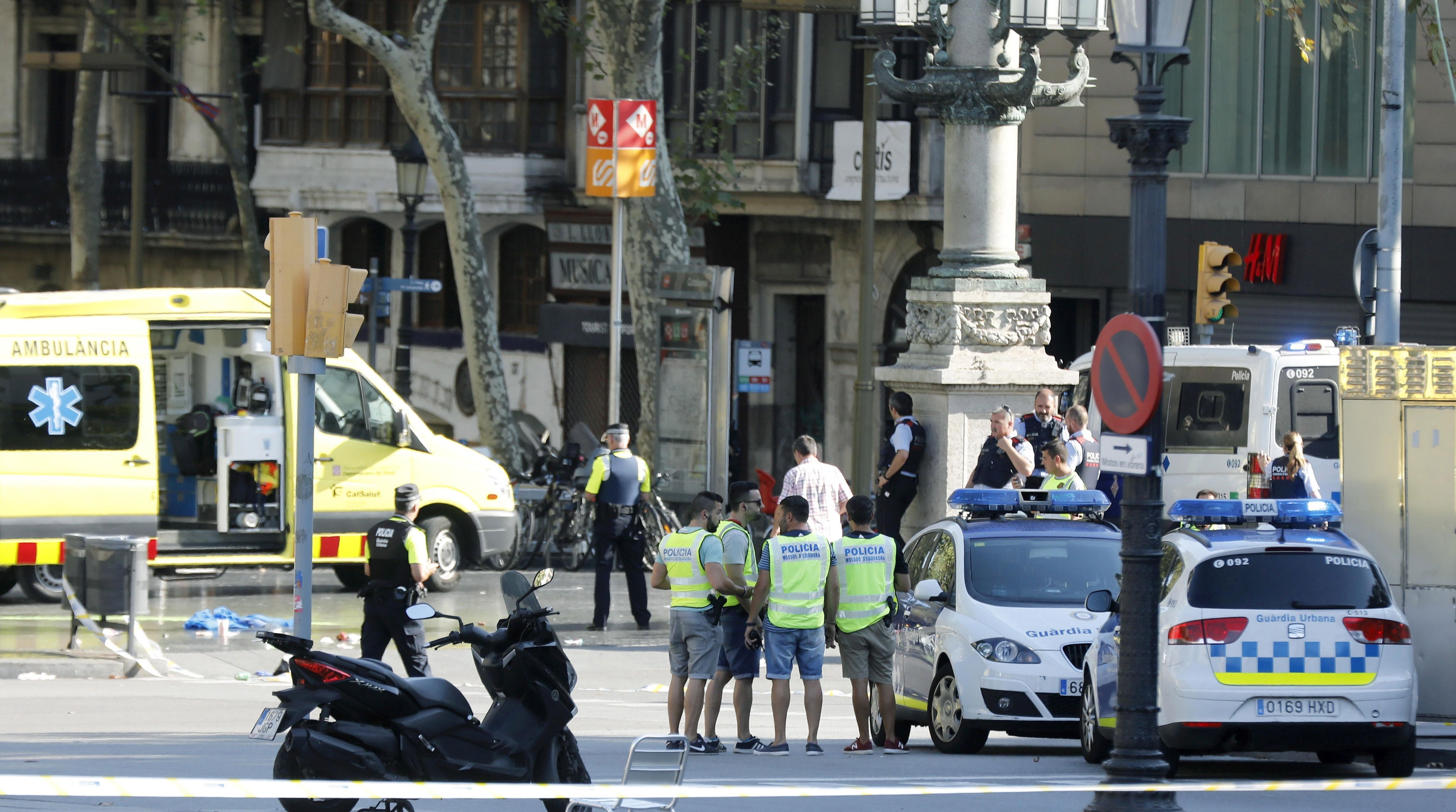 epa06148694 Mossos d'Esquadra Police officers and emergency service workers set up a security perimeter near the site where a van crashes into pedestrians in Las Ramblas, downtown Barcelona, Spain, 17 August 2017. According to initial reports a van crashed into a crowd in Barcelona's famous Placa Catalunya square at Las Ramblas area injuring several. Local media report the van driver ran away, metro and train stations were closed. The number of people injured and the reasons behind the incident are not yet known. Official sources have not confirmed that the incident is a terrorist attack.  EPA/Andreu Dalmau
