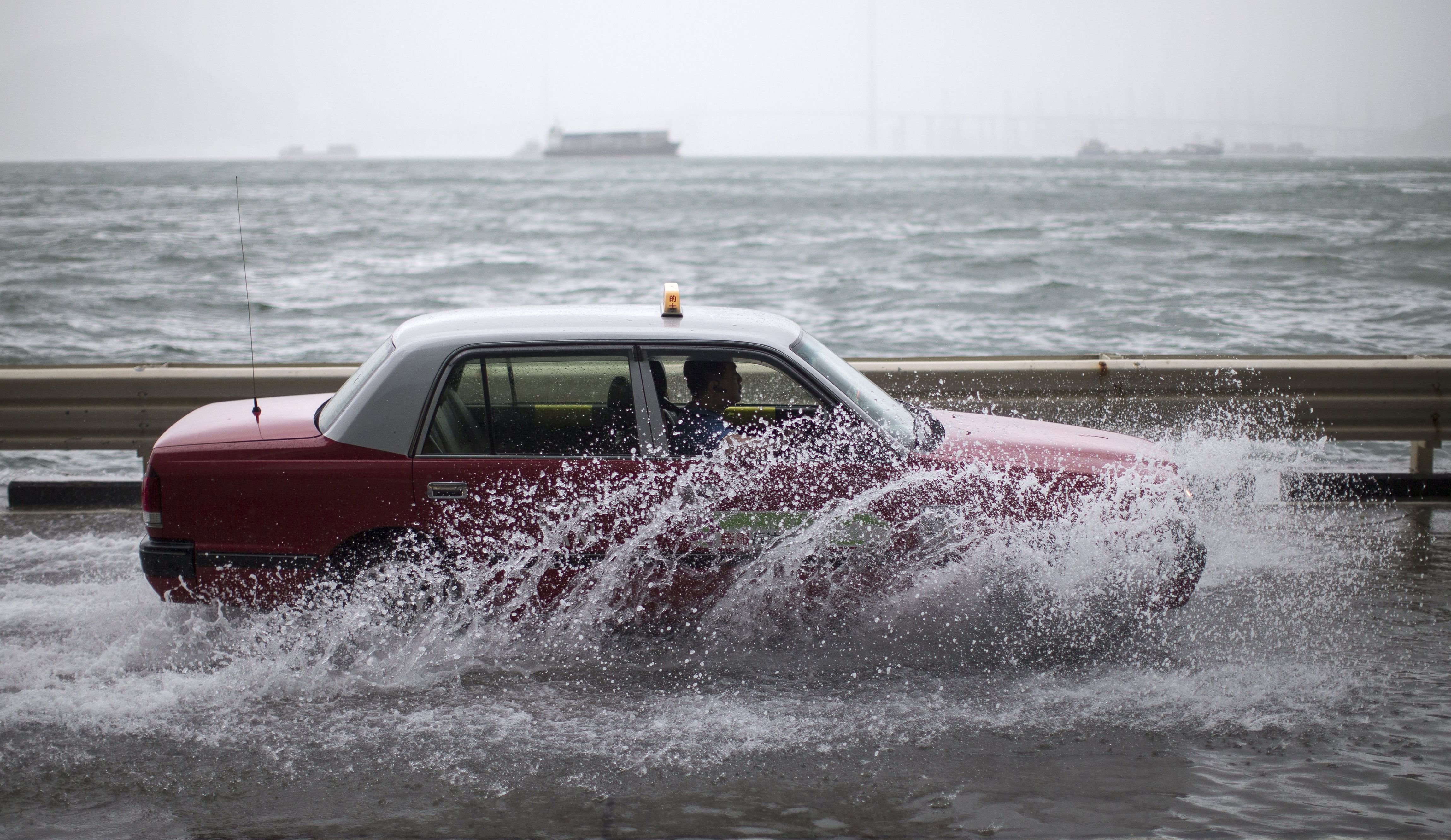 epa06157021 A taxi drives on a flooded street as typhoon Hato passes by in Hong Kong, China, 23 August 2017. Typhoon signal No 10, the highest in Hong Kong's storm warning system, was issued on 23 August.  EPA/JEROME FAVRE