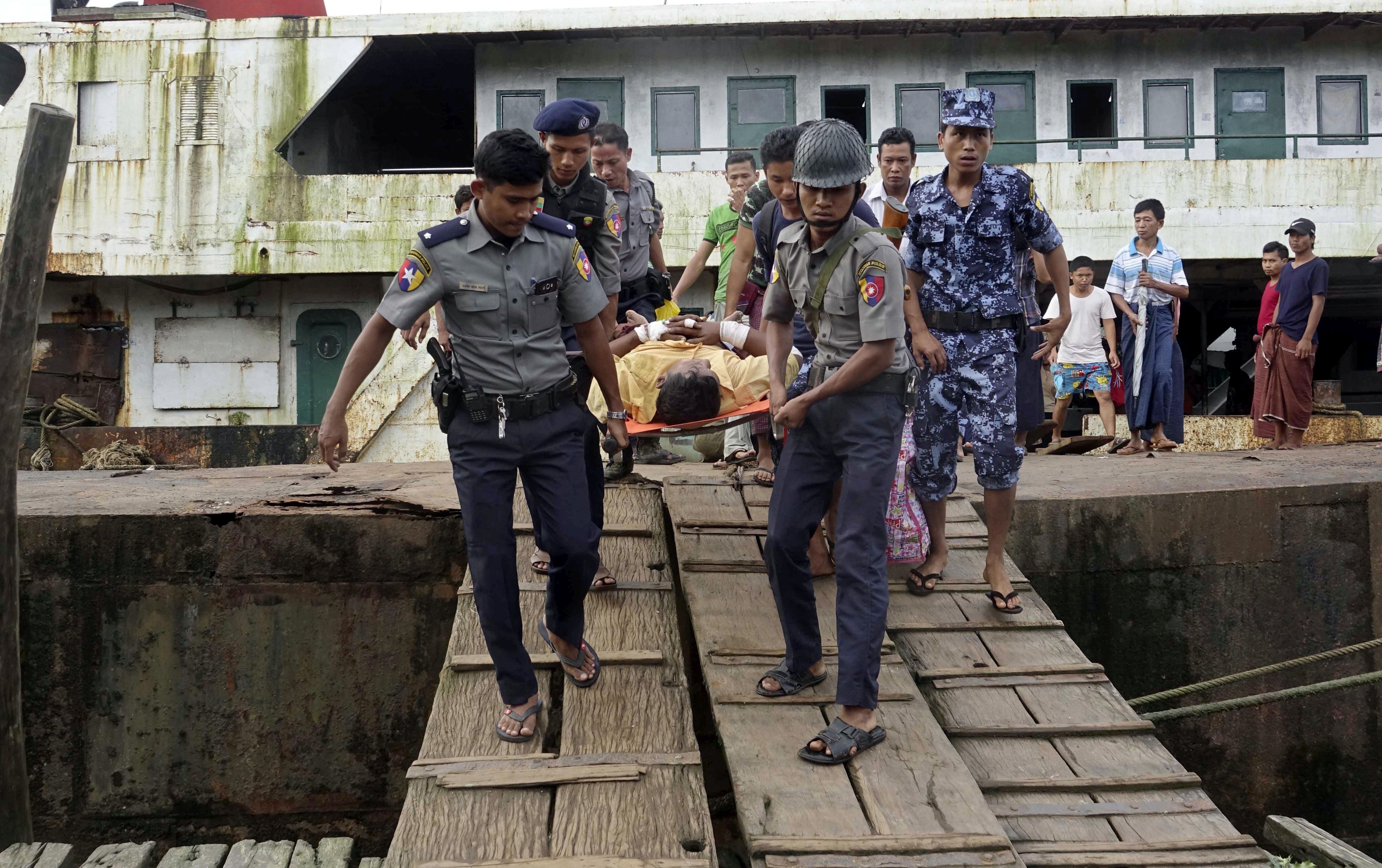 epa06164249 Myanmar policemen carry an injured border guard police (C) as he arrives to the Sittwe port, Sittwe, Rakhine State, western Myanmar, 26 August 2017. According to a statement by the Myanmar Armed Forces, at least 32 people, including 11 law enforcement officials, were killed on 25 August in Myanmar after Rohingya militants attacked police outposts and an army base in the western state of Rakhine.  EPA/NYUNT WIN