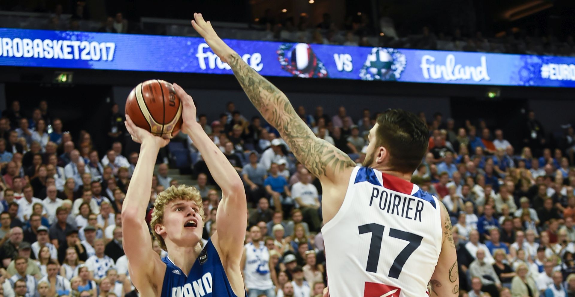 epa06174901 FinlandÂ´s Lauri Markkanen (L) in action against  FranceÂ´s Vincent Poirier  (R) during the EuroBasket 2017 group match between Finland and France in Helsinki, Finland, 31 August 2017.  EPA/MARKKU OJALA