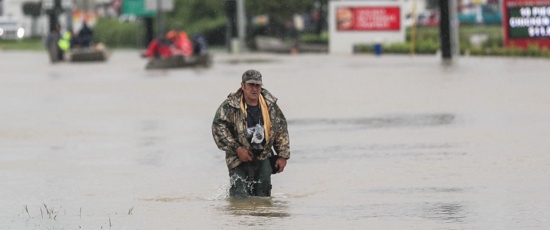 epa06170901 A man walks through floodwaters in the aftermath of Hurricane Harvey in Houston, Texas, USA, 29 August 2017. Hurricane Harvey made landfall on the south coast of Texas as a major hurricane category 4. The last time a major hurricane of this size hit the United States was in 2005.  EPA/TANNEN MAURY