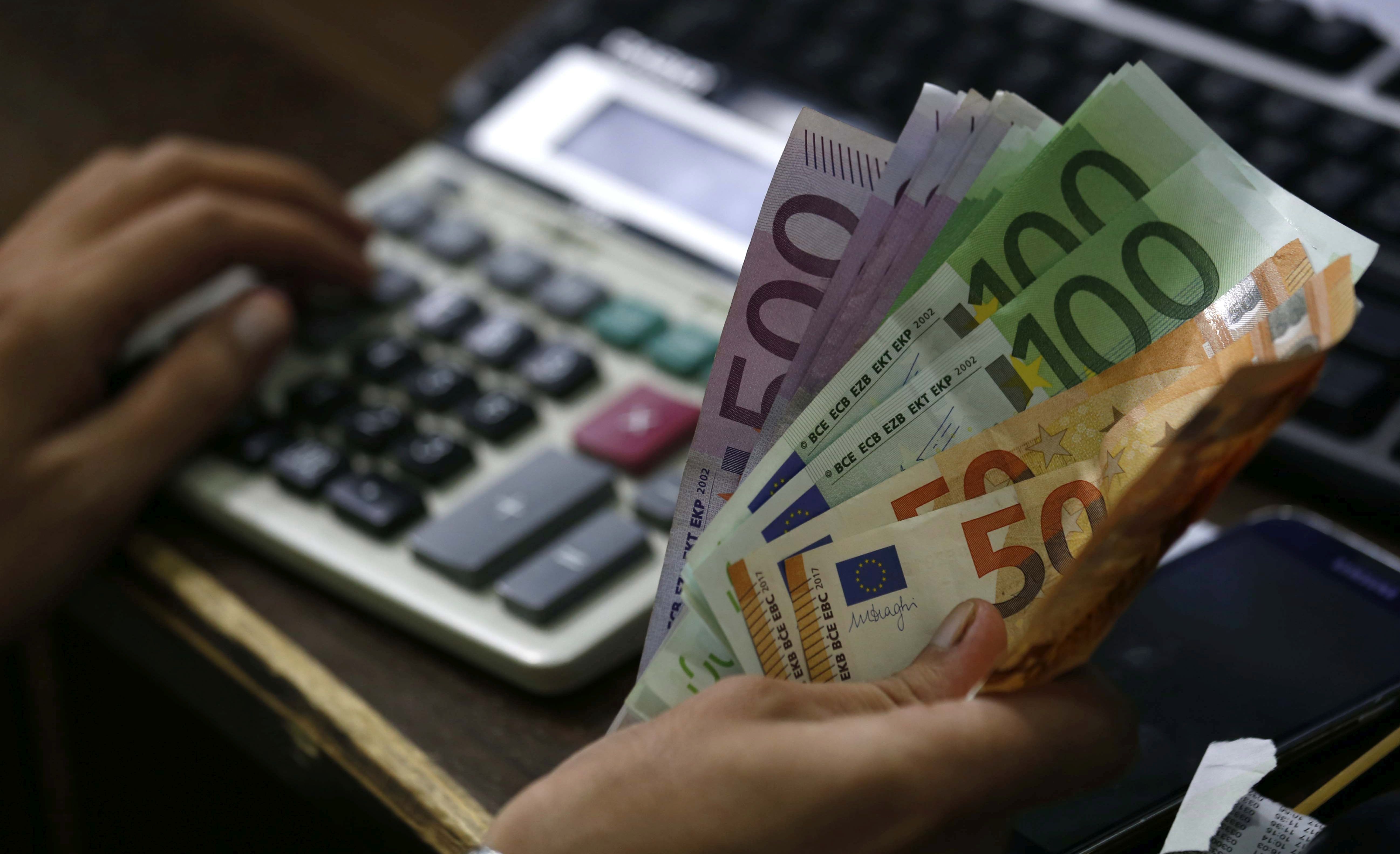 epa06170179 A worker counts Euro banknotes at a money exchange company in Peshawar, Pakistan, 29 August 2017. The Euro jumped against the US dollar on 29 August recording $ 1.2 for the first time in 18 months.  EPA/ARSHAD ARBAB