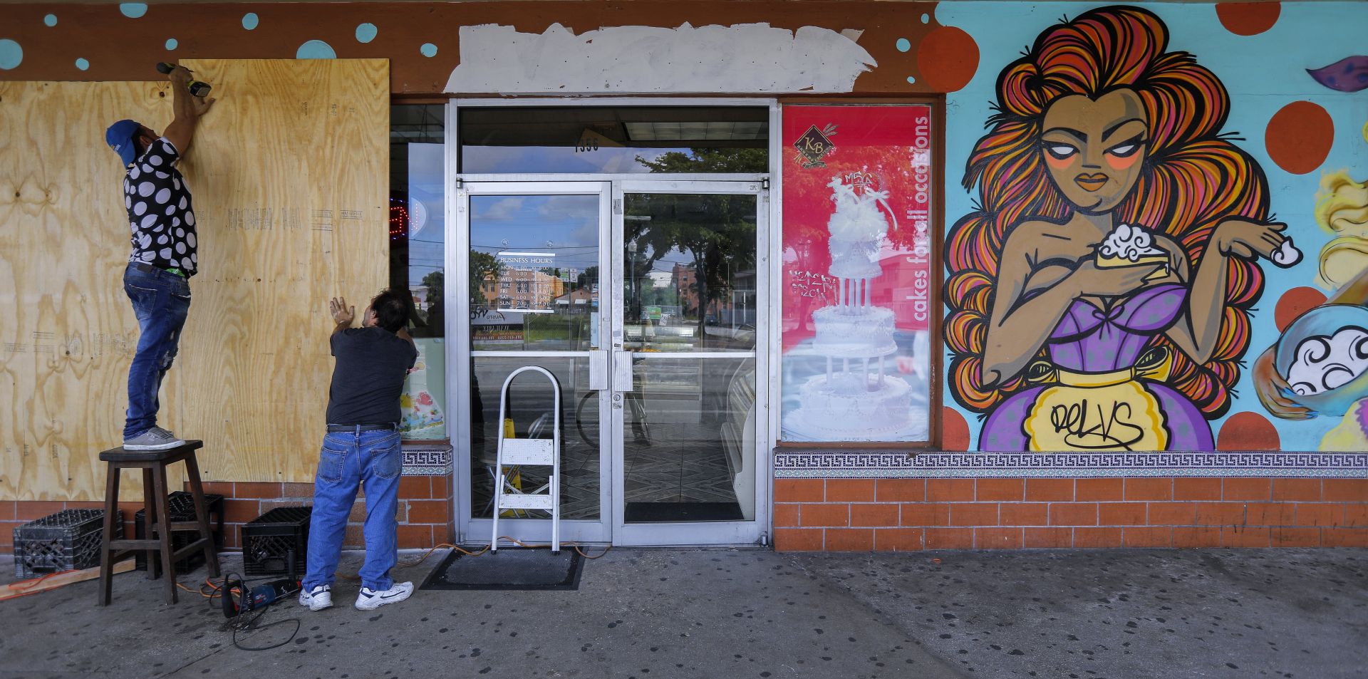 epa06193098 Workers put plywood over the windows of Yisell Bakery on Calle Ocho in the Little Havana neighborhood ahead of the expected arrival of Hurricane Irma in Miami, Florida, USA, 08 September 2017. Miami Beach, the Florida Keys and other low-lying areas are under a mandatory evacuation order ahead of Irma.  EPA/ERIK S. LESSER