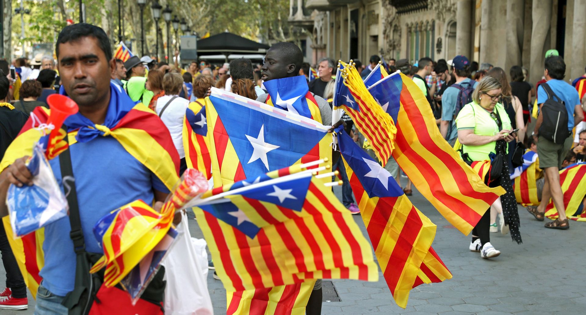 epa06198287 Street mongers sell Catalonian flags outside Casa Batllo during the National Day of Catalonia (Diada) in Barcelona, Catalonia, Spain, 11 September 2017. Large crowds are expected to hold rallies on Diada Day, related to a disputed regional independence referendum to be held in Catalonia in October.  EPA/Toni Albir