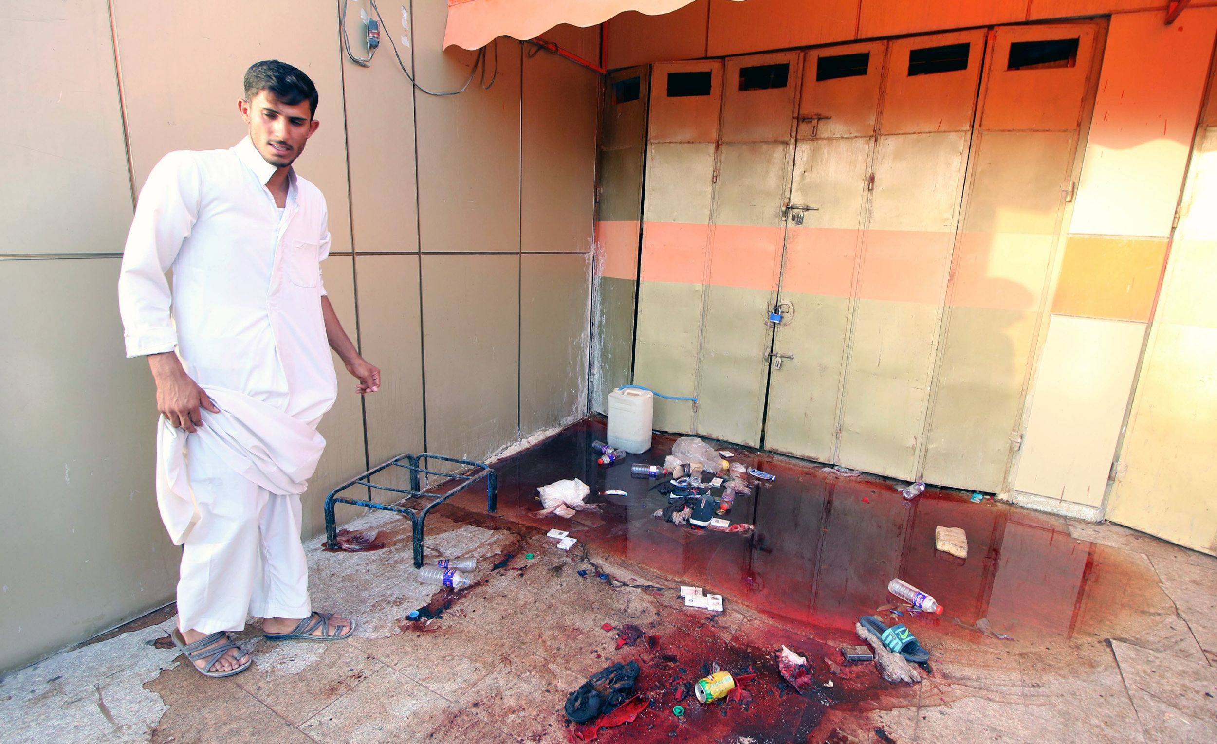 epa06204812 An Iraqi man stands near blood-stained pond at the site of a bomb attack in Nasiriyah city, about 350 km south of Baghdad, Iraq, 14 September 2017. According to security officials, Suicide bombers attacked a restaurant and a police checkpoint simultaneously on a highway near the southern Iraqi city of Nasiriyah killing at least 50 and wounding more than 80. The Islamic State (IS) claimed responsibility for the attack.  EPA/HAIDER AL-ASSADEE ATTENTION: GRAPHIC CONTENT