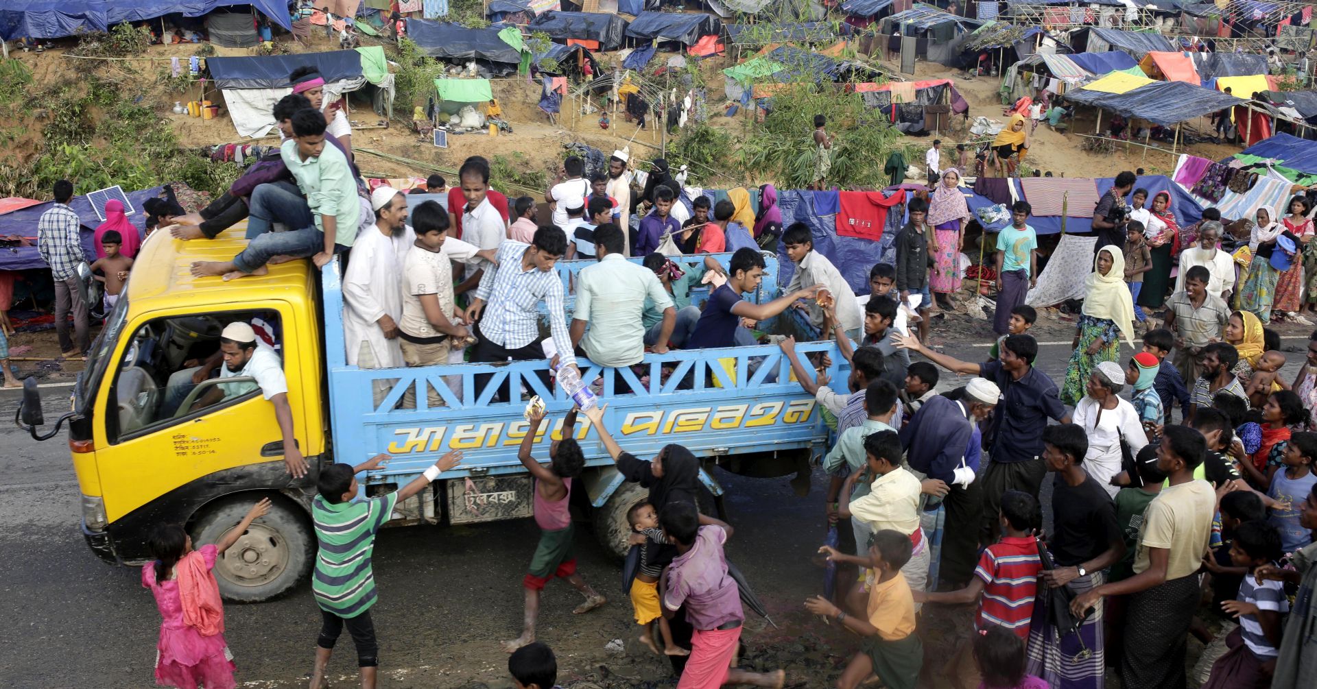 epa06210705 Rohingya refugees try to catch the relief from a truck at Tangkhali, Ukhiya, Bangladesh, 17 September 2017. According to UNHCR more than 400 thousand Rohingya refugees have fled Myanmar from violence over the last few weeks, most trying to cross the border and reach Bangladesh. International organizations have reported claims of human rights violations and summary executions allegedly carried out by the Myanmar army.  EPA/ABIR ABDULLAH