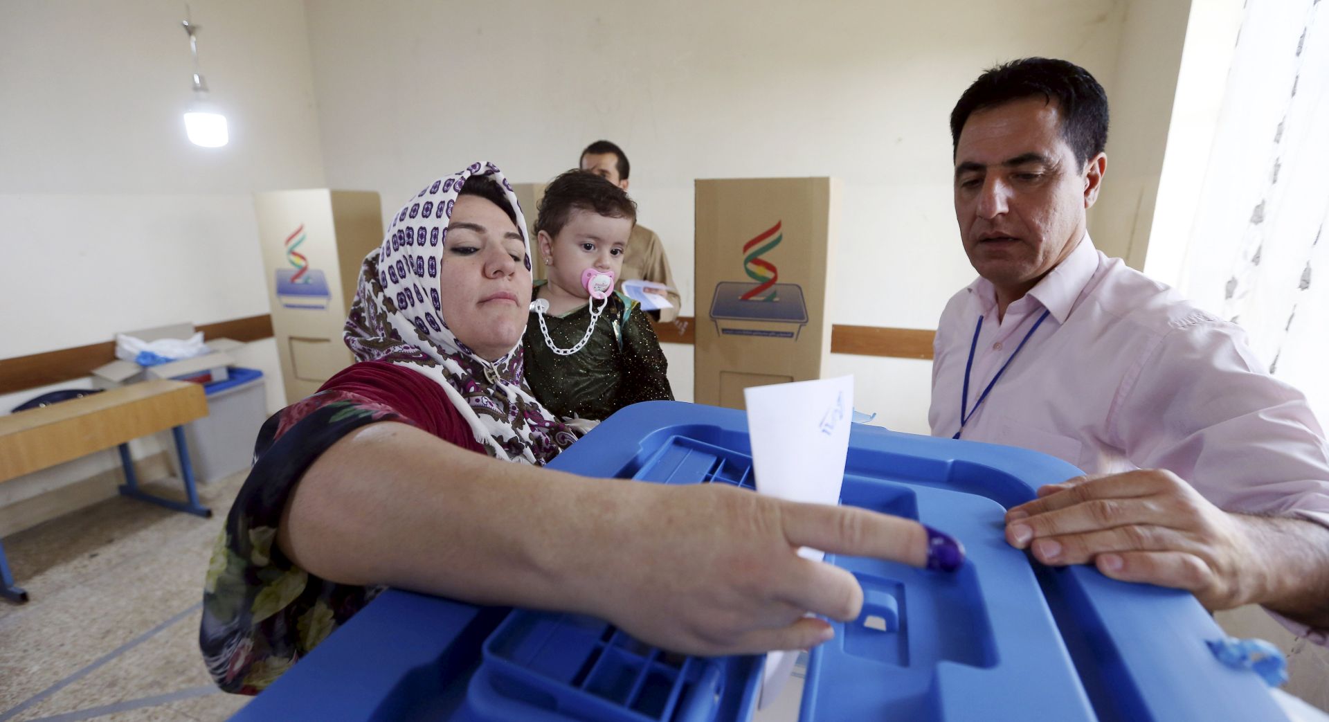 epa06225378 An Iraqi Kurd woman picks up ballot paper before casting her vote at a polling station during Kurdistan independence referendum in Erbil, Kurdistan region in northern Iraq, 25 September 2017. The Kurdistan region is an autonomous region in northern Iraq since 1991, with an estimated population of 5.3 million people. The region share borders with Turkey, Iran, and Syria, all of which have large Kurdish minorities. On 25 September the Kurdistan region holds a referendum for independence and the creation of the state of Kurdistan amidst divided international support.  EPA/MOHAMED MESSARA