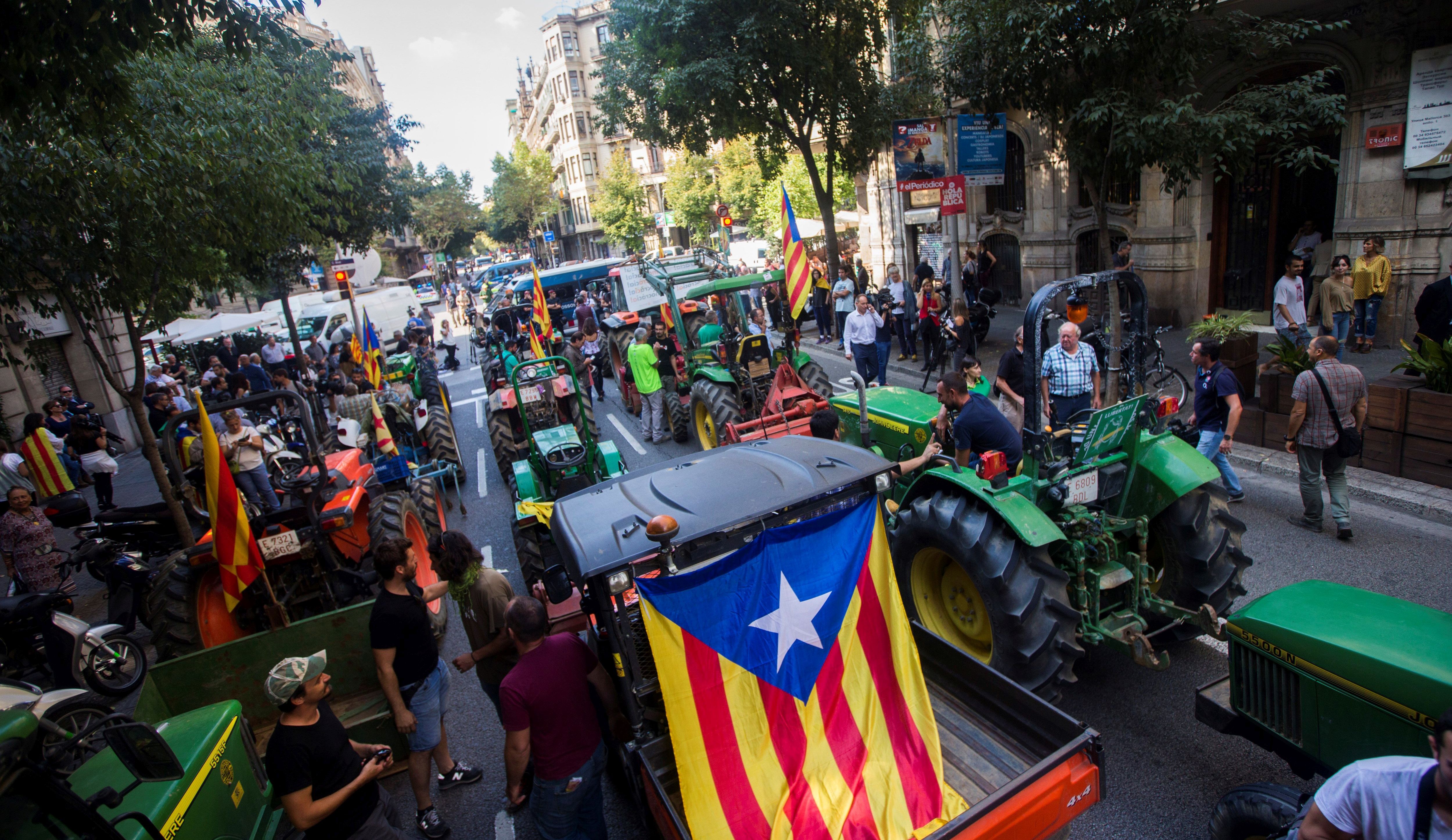 epa06234238 Tractors prevent the Mossos d'Esquadra (Catalan regional police) from continuing their way towards the Catalan Government's hedquarters as they protest in support of the '1-O Referendum' in Barcelona, northeastern Spain, on 29 September 2017. Catalonia is to hold an independence referendum on 01 October 2017 in spite of it has been banned by the Constitutional Court.  EPA/Quique Garcia