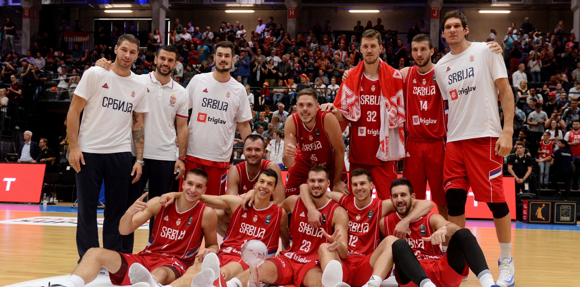 The Serbian national basketball team poses with the trophy after winning the Supercup fixture betweem Germany and Serbia at the edel-optics.de Arena in Hamburg, Germany, 20 August 2017. Photo: Daniel Reinhardt/dpa