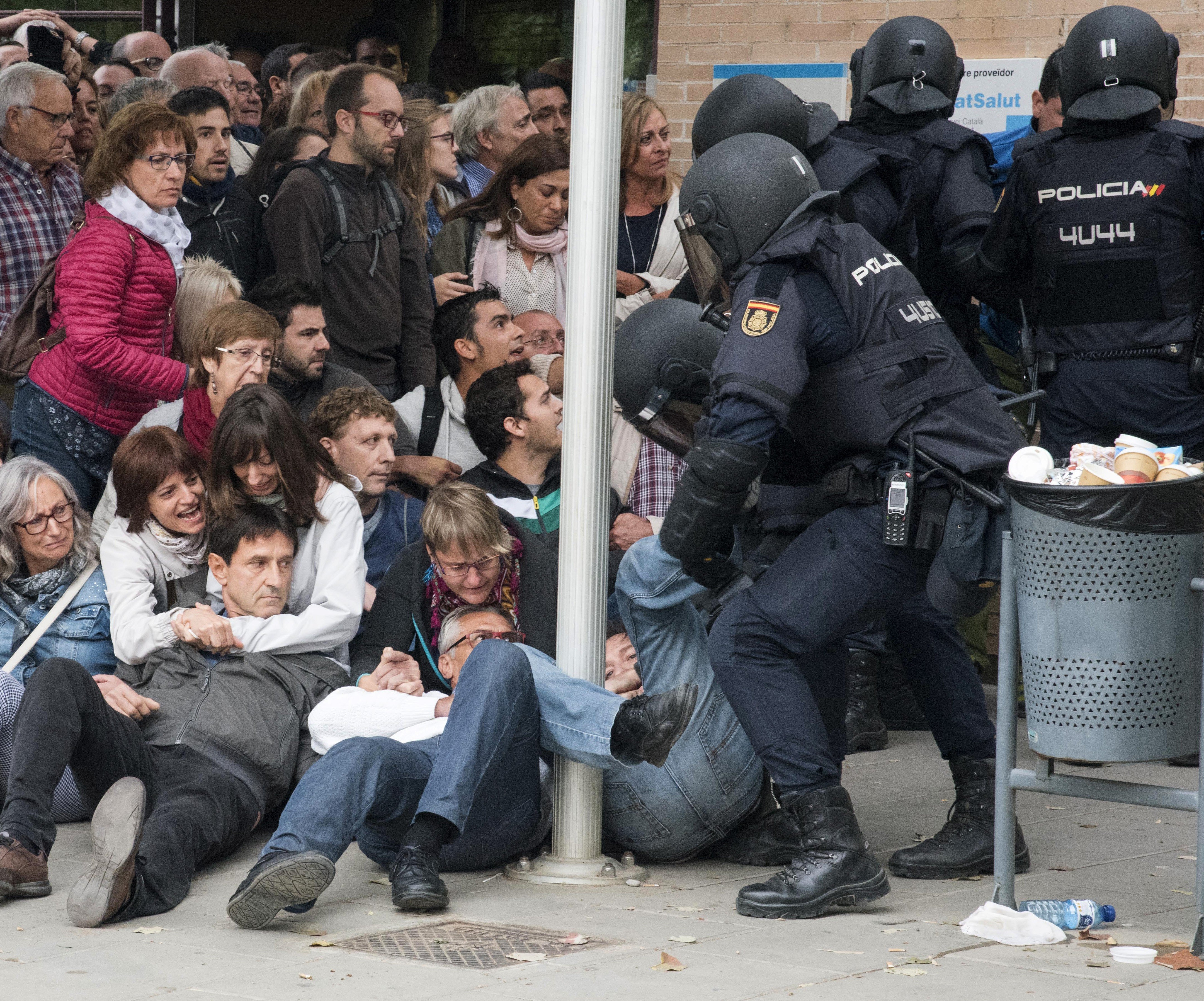 epa06237426 Catalan people are being moved outside at a polling center set at a health clinic clash with Spanish National Police officers after police forces seized ballot boxes during the '1-O Referendum' in Cappont, Lleida, Catalonia, northeastern Spain, on 01 October 2017. National Police officers and Civil guards have been deployed to seize voting material and to prevent the people from entering to the polling centers and vote in the Catalan independence referendum, that has been banned by the Spanish Constitutional Court, what has provocked clashes between pro-independence people and the police forces in some poligon centers.  EPA/Adria Ropero