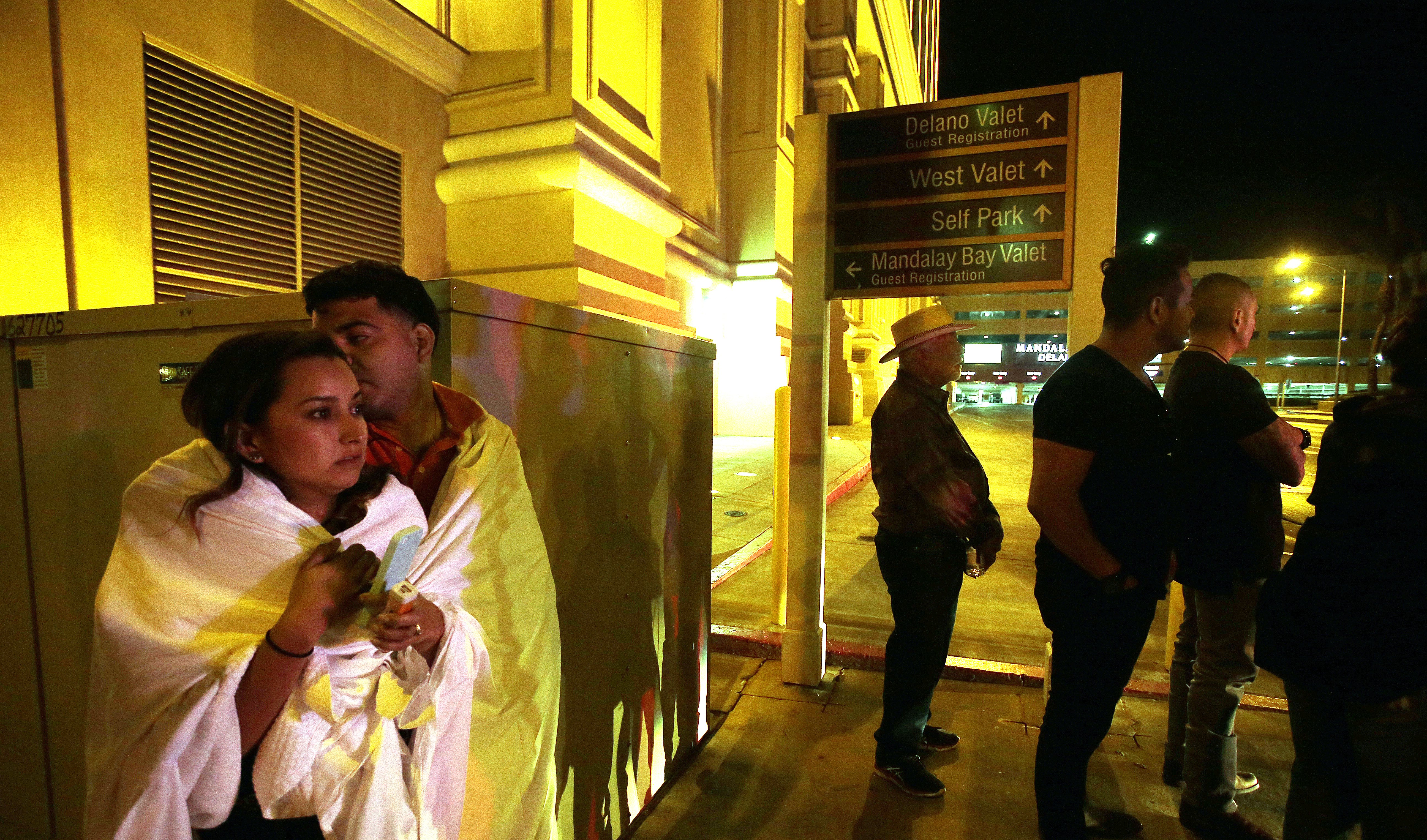 epa06239904 People stand on the street outside the Mandalay Bay hotel  near the scene of the Route 91 Harvest festival on Las Vegas Boulevard in Las Vegas, Nevada, USA, 02 October, 2017. Police reports indicate that a gunman firing from an upper floor in the Mandalay Bay hotel killed more than 50 people and injured more than 200 before police he was killed by police.  EPA/PAUL BUCK