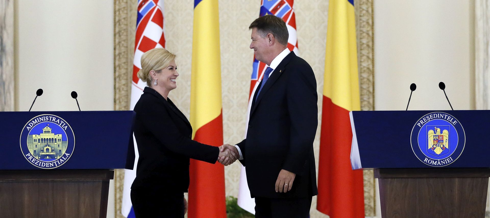 epa06240371 Croatian President Kolinda Grabar-Kitarovic (L) and Romanian President Klaus Iohannis (R) shake hands at a press conference held at Cotroceni Palace, in Bucharest, Romania, 02 October2017. Grabar-Kitarovic is on a one-day official visit to Romania.  EPA/ROBERT GHEMENT