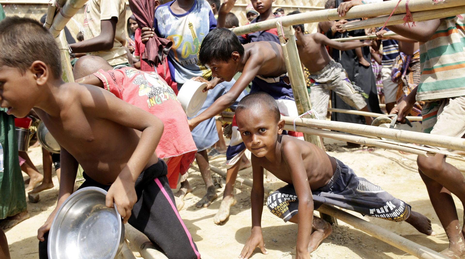 epa06259187 Rohingya children cross the bamboo fences to get into the queue to collect lunch time food center in a camp in Palonkhali, Coxsbazar, Bangladesh, 11 October 2017. United Nations High Commissioner for Refugees said on 10 October that around 11,000 Rohingyas crossed over into Bangladesh in a single day in a fresh surge of refugees fleeing an ongoing military offensive in Myanmar's Rakhine state. More than half a million Rohingyas, a Muslim minority in Myanmar mainly living in the Rakhine province, have fled to neighboring Bangladesh to escape the ongoing offensive by the Myanmar army that began on 25 Augugust, after Rohingya rebels had mounted attacks on multiple government posts in the region.  EPA/ABIR ABDULLAH
