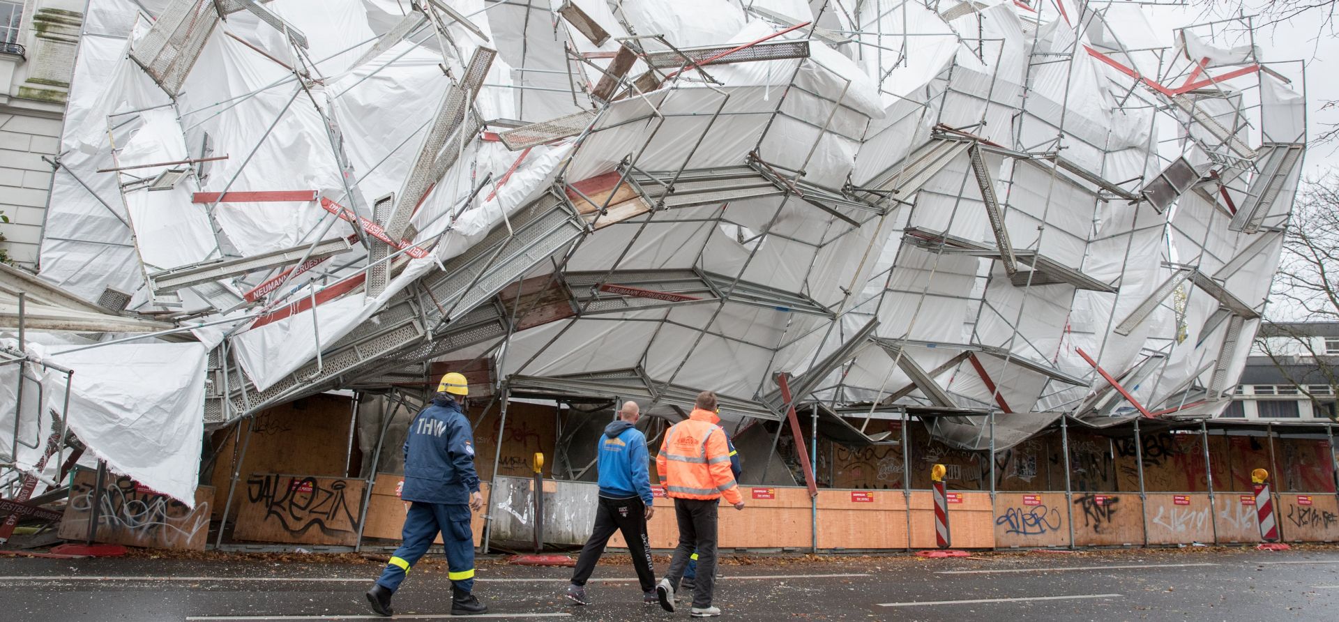 epa06296356 Emergency workers stand in front of scaffolding collapsed due to heavy winds in Berlin, Germany, 29 October 2017. A jogger was injured while passing the scaffold as the storm depression 'Herwart' travelled across Germany causing injuries and damage.  EPA/ALEXANDER BECHER
