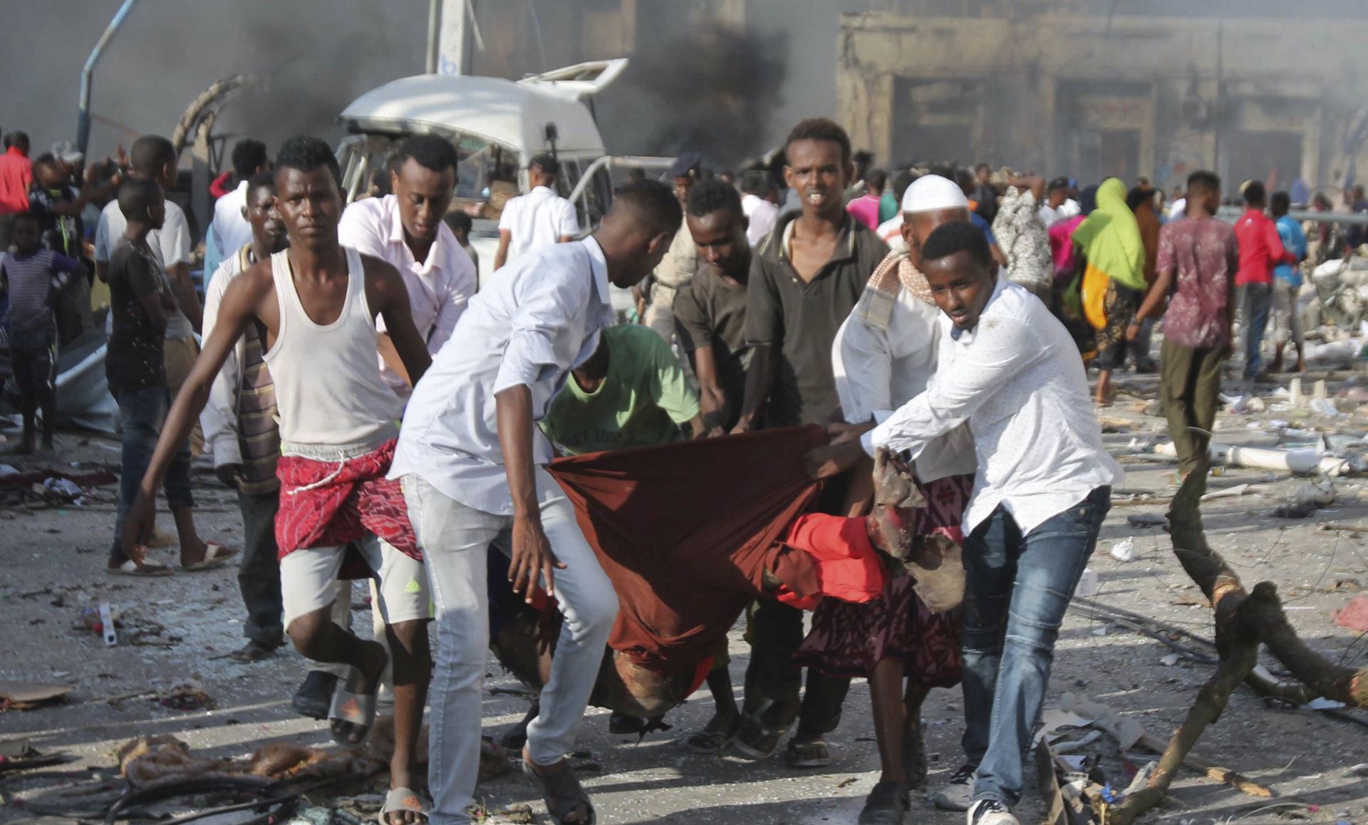 epa06265445 People carry a victim out of the scene of a massive explosion in front of Safari Hotel in the capital Mogadishu, Somalia, 14 October 2017. Reports state at least 20 peole have been killed when a truck bomb went off on a busy street in central Mogadishu. There was no immediate claim of responsibility but the country's Islamist militant group al-Shabab often carries out similar attacks in the capital.  EPA/SAID YUSUF WARSAME