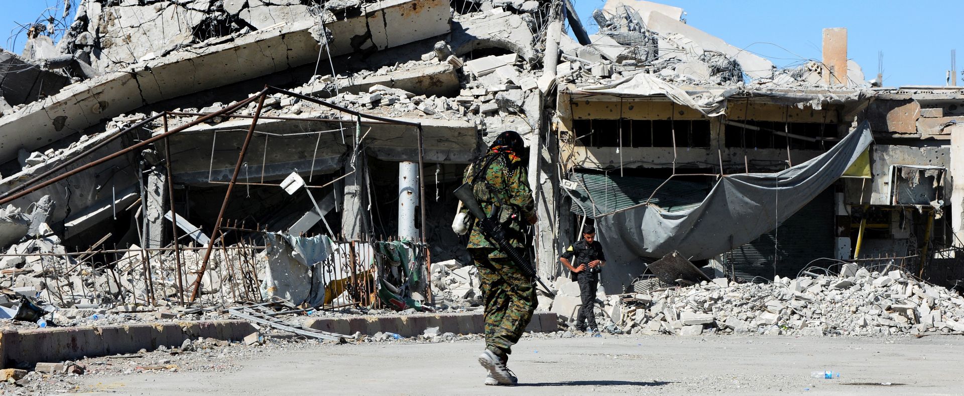 epa06274760 A fighter from the Syrian Democratic Forces (SDF) walks near the Al-Na'im roundabout in central Al-Raqqa, Syria, 18 October 2017 (issued 19 October 2017). The Al-Na'im roundabout also known as the 'Roundabout of Hell', located in the center of the city of Al-Raqqa, has been the last to be liberated by US backed Syrian forces from the grip of the organization of the so-called Islamic State (IS, ISIS or ISIL). The roundabout was used by ISIS extremists to perform public executions, beheadings and crucifixions during their three-year rule of the city.  EPA/YOUSSEF RABIH YOUSSEF