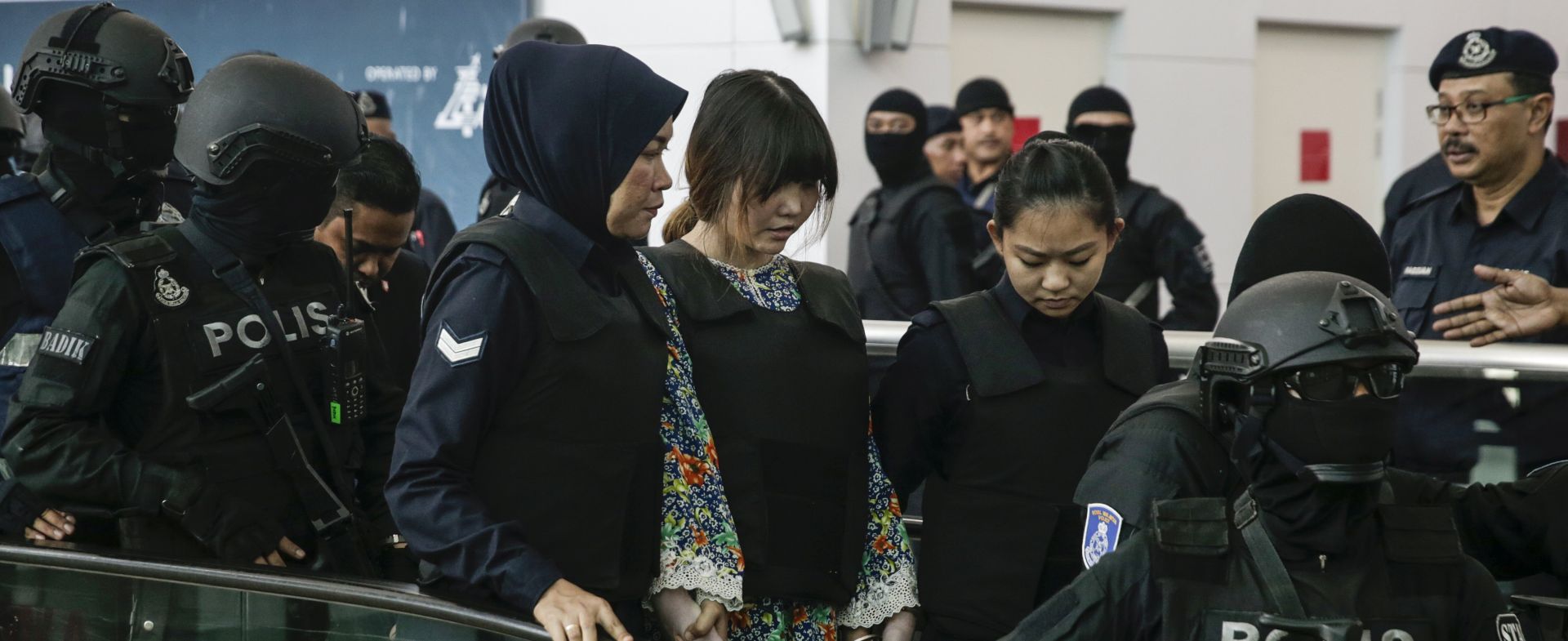 epa06285251 Doan Thi Huong (C) of Vietnam - who is on trial for the assasination of Kim Jong-nam, the estranged half-brother of North Korea's leader Kim Jong-un - is escorted as she revisits scene of the attack at Kuala Lumpur International Airport 2 in Sepang, Malaysia, 24 October 2017.  Doan Thi Huong from Vietnam and Siti Aisyah from Indonesia, charged with murder under Section 302 of the penal code, which carries mandatory death sentence if found guilty, pleaded not guilty during the murder trial.  EPA/FAZRY ISMAIL
