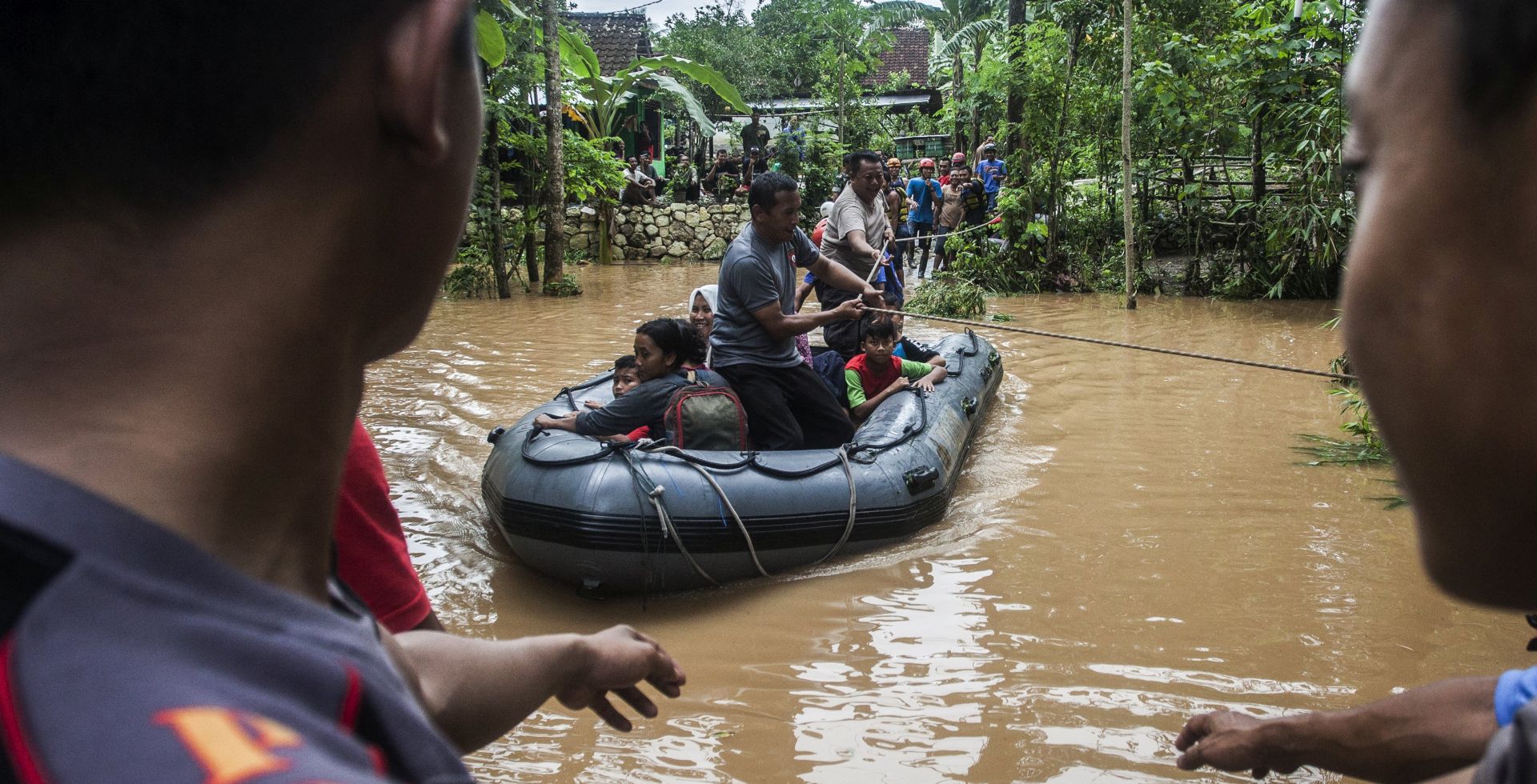 epa06357074 Indonesian police and rescue officers evacuate residents from a flooded village in Gunung Kidul, Yogyakarta, Indonesia, 29 November 2017. According to media reports, at least 19 people were killed following landslides and floods triggered by a cyclone in waters off Indonesia's Java island.  EPA/KOKO