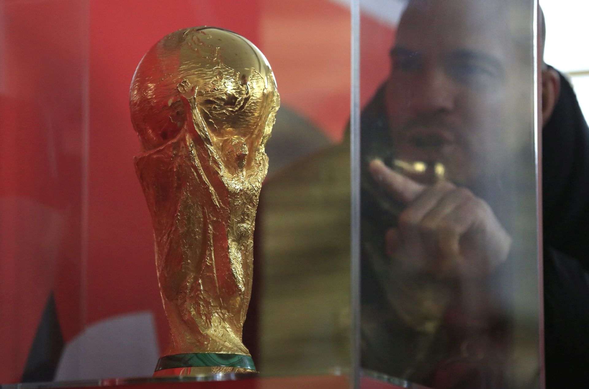 epa06357098 A man points to the World Cup trophy during a demonstration in the media centre prior to the FIFA World Cup 2018 Final Draw in the State Kremlin Palace in Moscow, Russia, 28 November 2017. The Final Draw for the FIFA World Cup 2018 in Russia will take place in Moscow on 01 December 2017.  EPA/SERGEI ILNITSKY