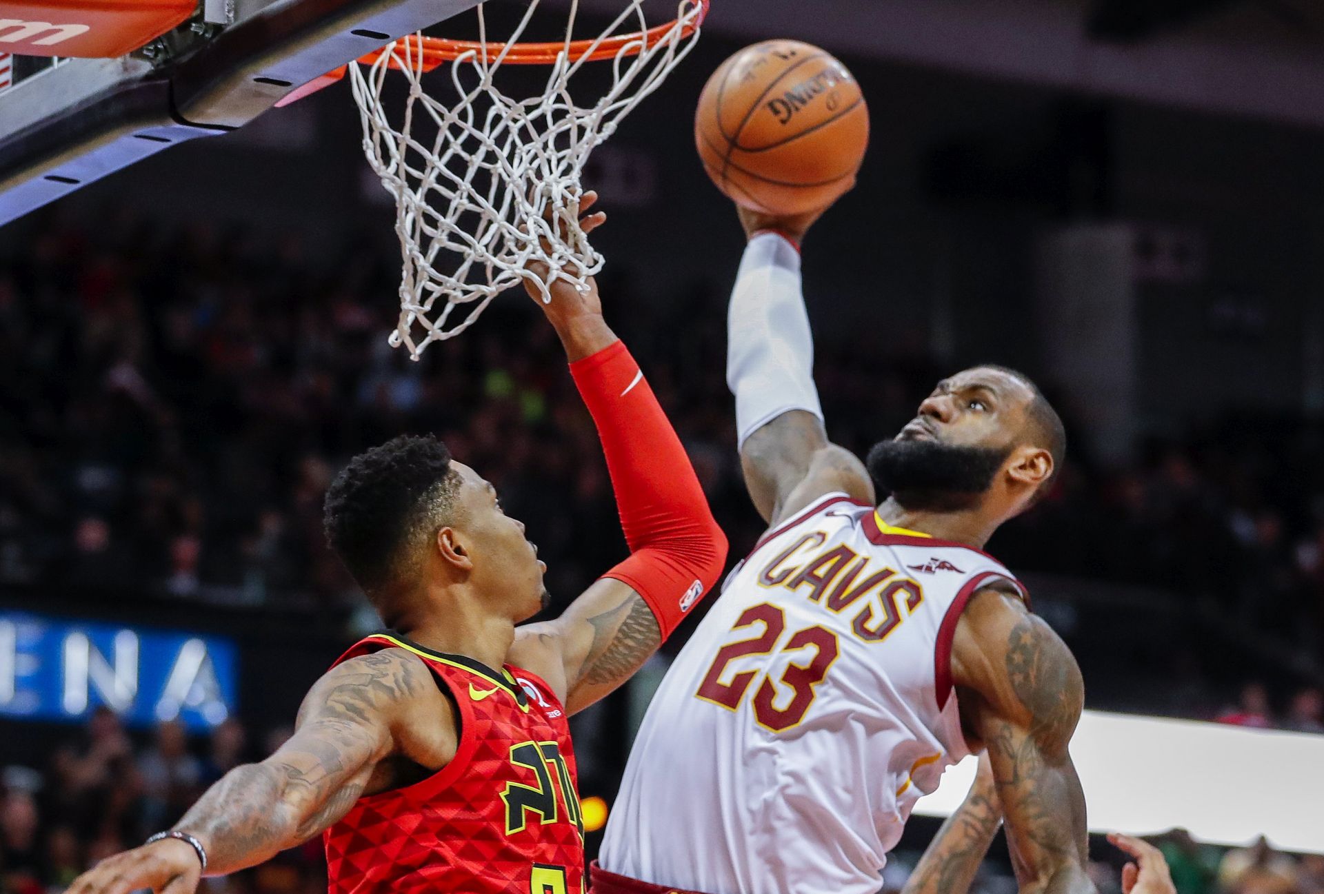 epa06360429 Cleveland Cavaliers forward LeBron James (C) dunks the ball between Atlanta Hawks guard Kent Bazemore (L) and Hawks forward John Collins (R) during the first half of the NBA basketball game between the Cleveland Cavaliers and the Atlanta Hawks at Philips Arena in Atlanta, Georgia, USA, 30 November 2017.  EPA/ERIK S. LESSER