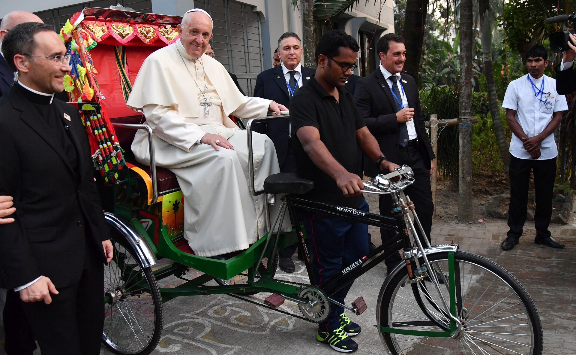 epa06361080 Pope Francis (2-L) enters with a rickshaw at an Interreligious and Ecumenical meeting for peace at the garden of the Archbishopric in Dhaka, Bangladesh, 01 December 2017. Pope Francis' visit in Myanmar and Bangladesh runs from 27 November to 02 December 2017.  EPA/ETTORE FERRARI