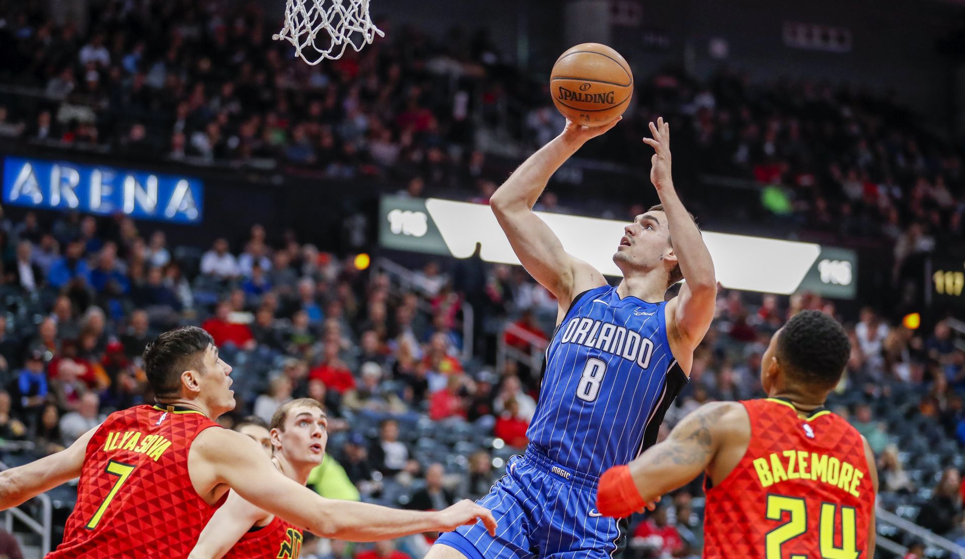epa06380300 Orlando Magic guard Mario Hezonja (C) of Croatia shoots against Atlanta Hawks forward Ersan Ilyasova (L) of Turkey and Hawks guard Kent Bazemore (R) during the first half of the NBA basketball game between the Orlando Magic and the Atlanta Hawks at Philips Arena in Atlanta, Georgia, USA, 09 December 2017.  EPA/ERIK S. LESSER