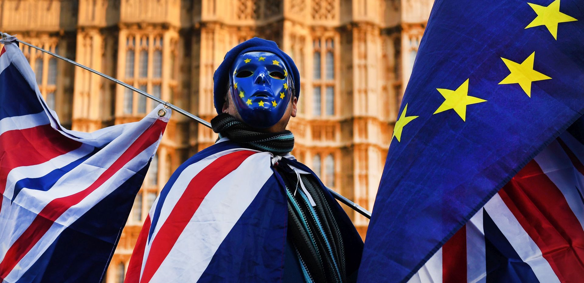 epa06397380 Pro EU protester wearing a mask with EU stars and holding EU and British flags demonstrates outside the Parliament in London, Britain, 18 December 2017. British Prime Minister Theresa May makes a statement on Brexit and EU Summit at parliament on 18 December.  EPA/ANDY RAIN