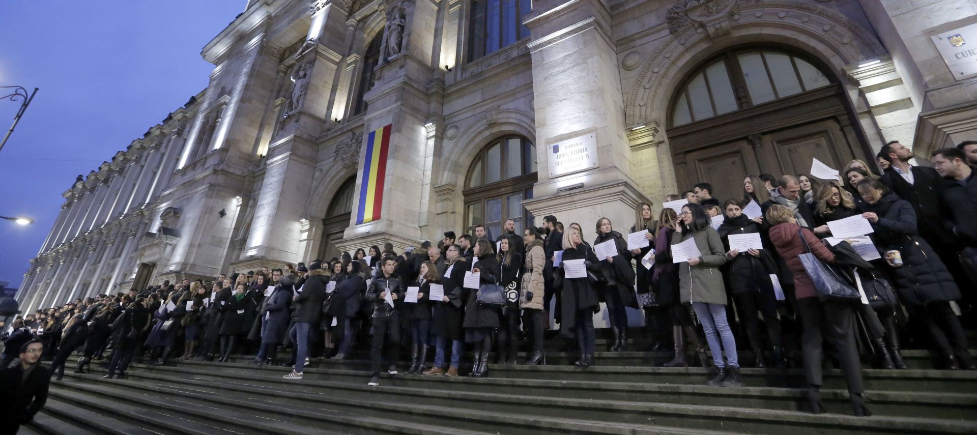 epa06397421 Romanian prosecutors stand still while holding placards on the stairs of  Appeal Court building during a silent protest against the non-transparent amendment of the laws of Justice pushed in parliament by the ruling leftist coalition, in , Bucharest, Romania, 18 December 2017. Hundreds of prosecutors from Bucharest, and as well from big cities across the country,  protested today in front of their Justice Appeal courts against the Romanian parliament's plans to change the justice law. The placards are depicting the Romanian Prosecutor's Oath.  EPA/ROBERT GHEMENT