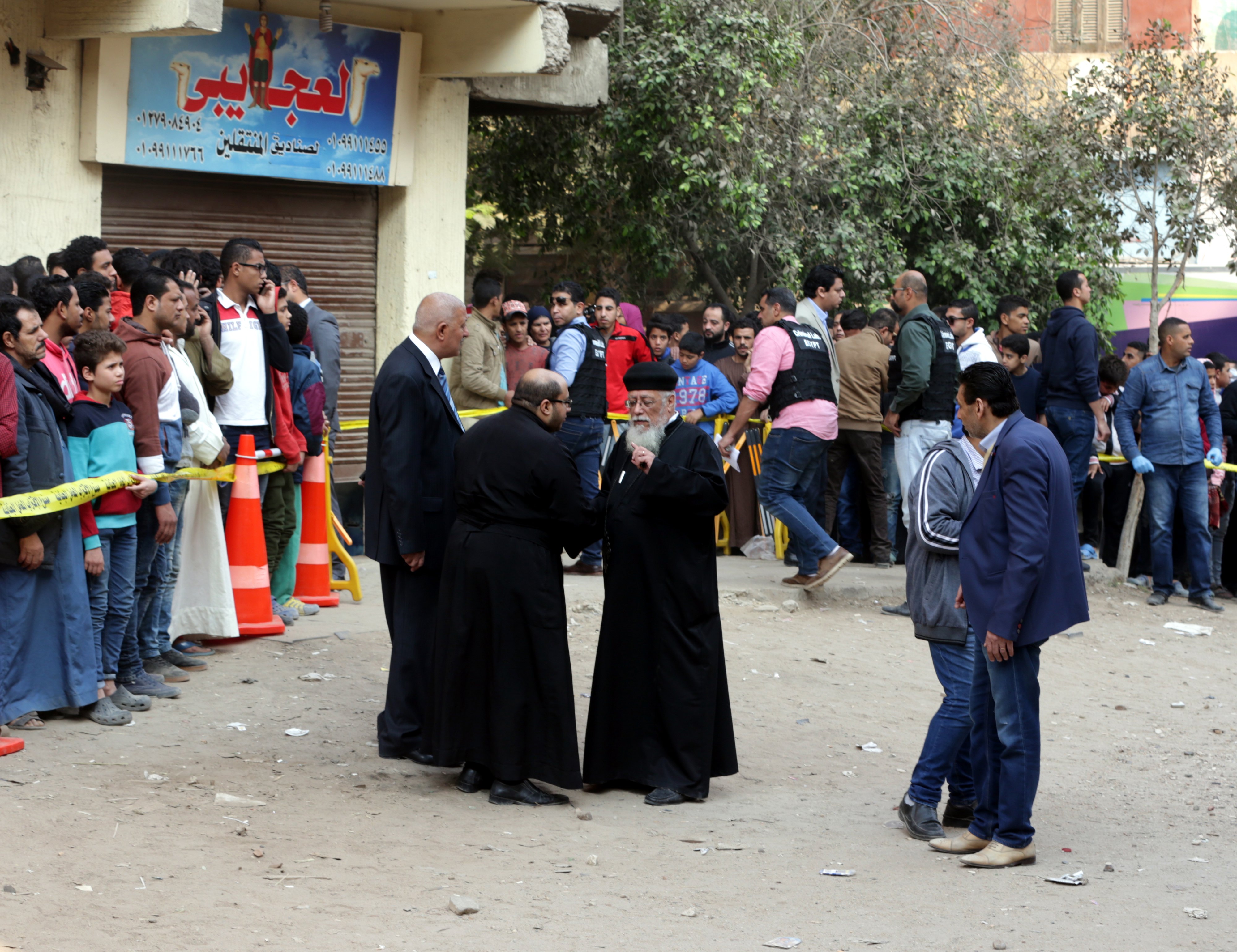 epa06408911 Security officials and people gather outside Mar Mina church following an attack on the church in the district of Helwan, southeastern Cairo, Egypt, 29 December 2017. At least five people were killed in gunfight after two assailants attempted to storm Mar Mina church in the working-class suburb of Helwan.  EPA/KHALED ELFIQI
