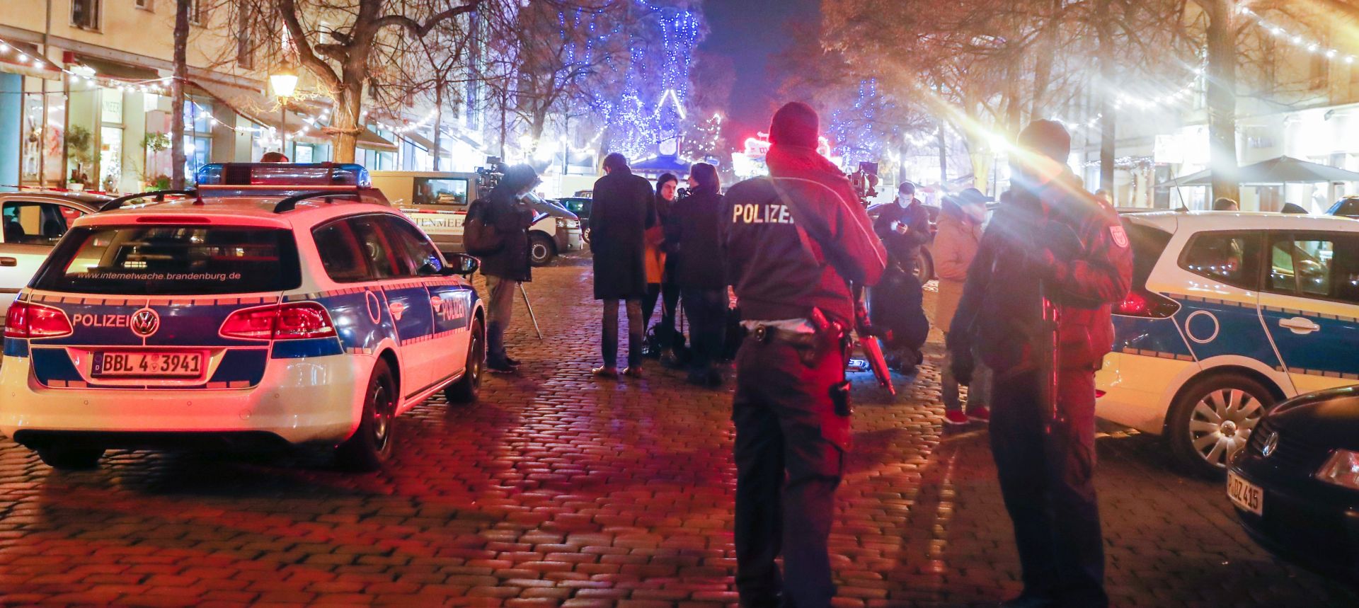 epa06362046 Policemen with machine guns stand next to journalists near an empty Christmas market, after it was evacuated by police, in Potsdam, Germany, 01 December 2017. Police said they had found an explosive device at Potsdam Christmas market, a city near Berlin, and defused it.  EPA/FELIPE TRUEBA