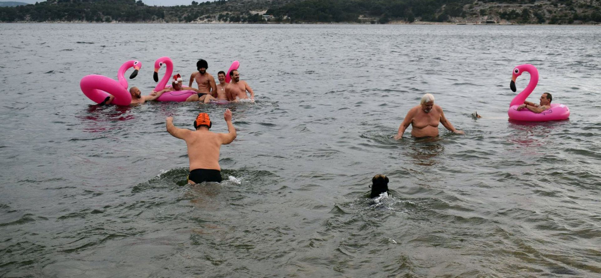 ibenik, 01.01.2018 - Osam ibenèana i jedan pas proslavili su prvi dan nove godine tradicionalnim kupanjem na gradskoj plai Banj, uz jugo i temperaturu zraka od osam stupnjeva Celzijevih. Toèno u podne, veæ prema tradiciji, hrabri su kupaèi, oboruani neizostavnim 'dodatkom' na plaama, rozim plamencem na napuhavanje, èestitali sugraðanima Novu godinu i utrèali u more praæeni zvucima Labuðeg jezera na violini i klaviru.
foto HINA/ ds
